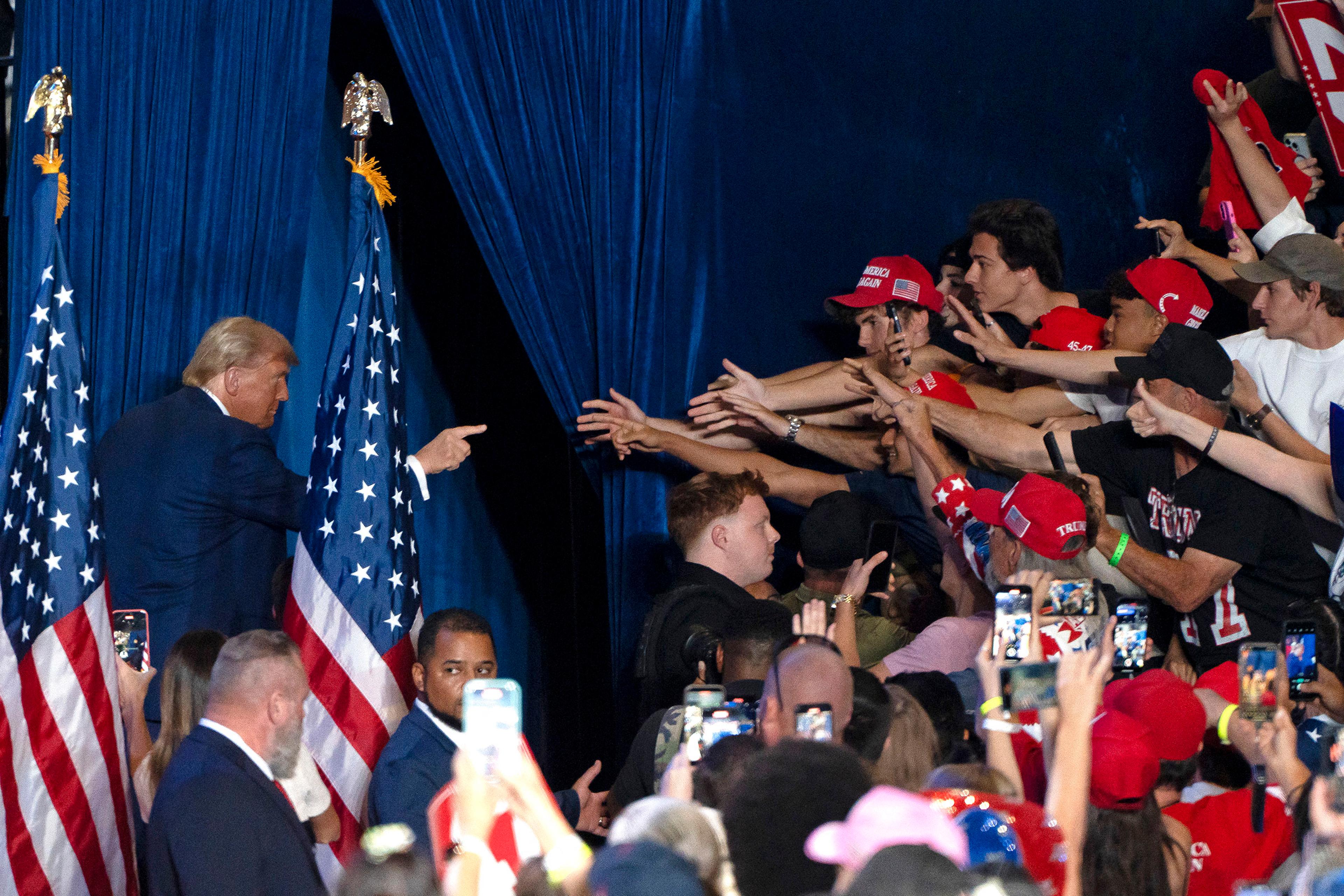 Trump gestures at supporters as he exits a campaign rally at Mullet Arena in Tempe, Ariz. on Oct. 24