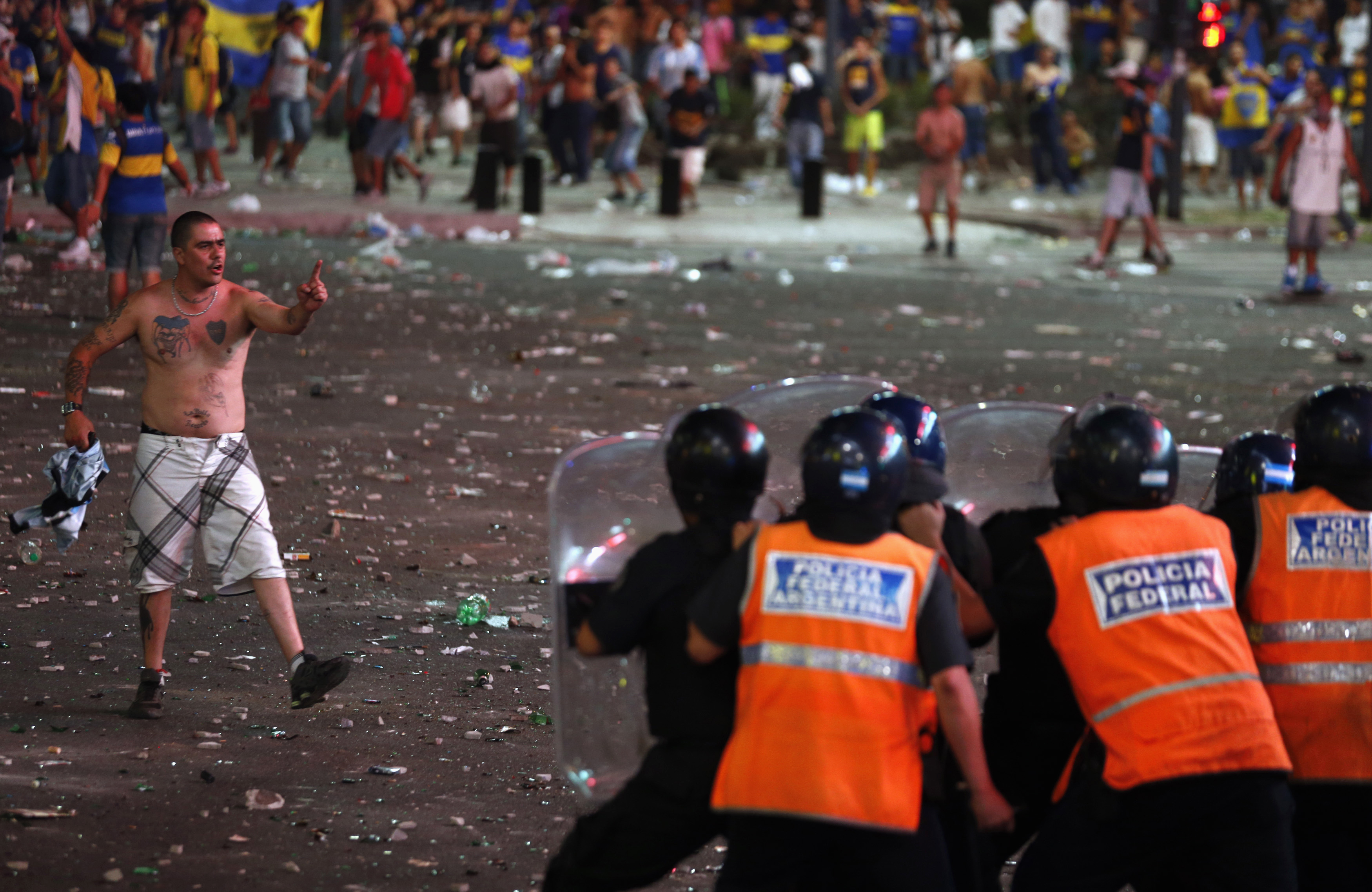 A fan of Argentine soccer team Boca Juniors confronts police during riots after celebrations of Boca Juniors Fan Day in Buenos Aires