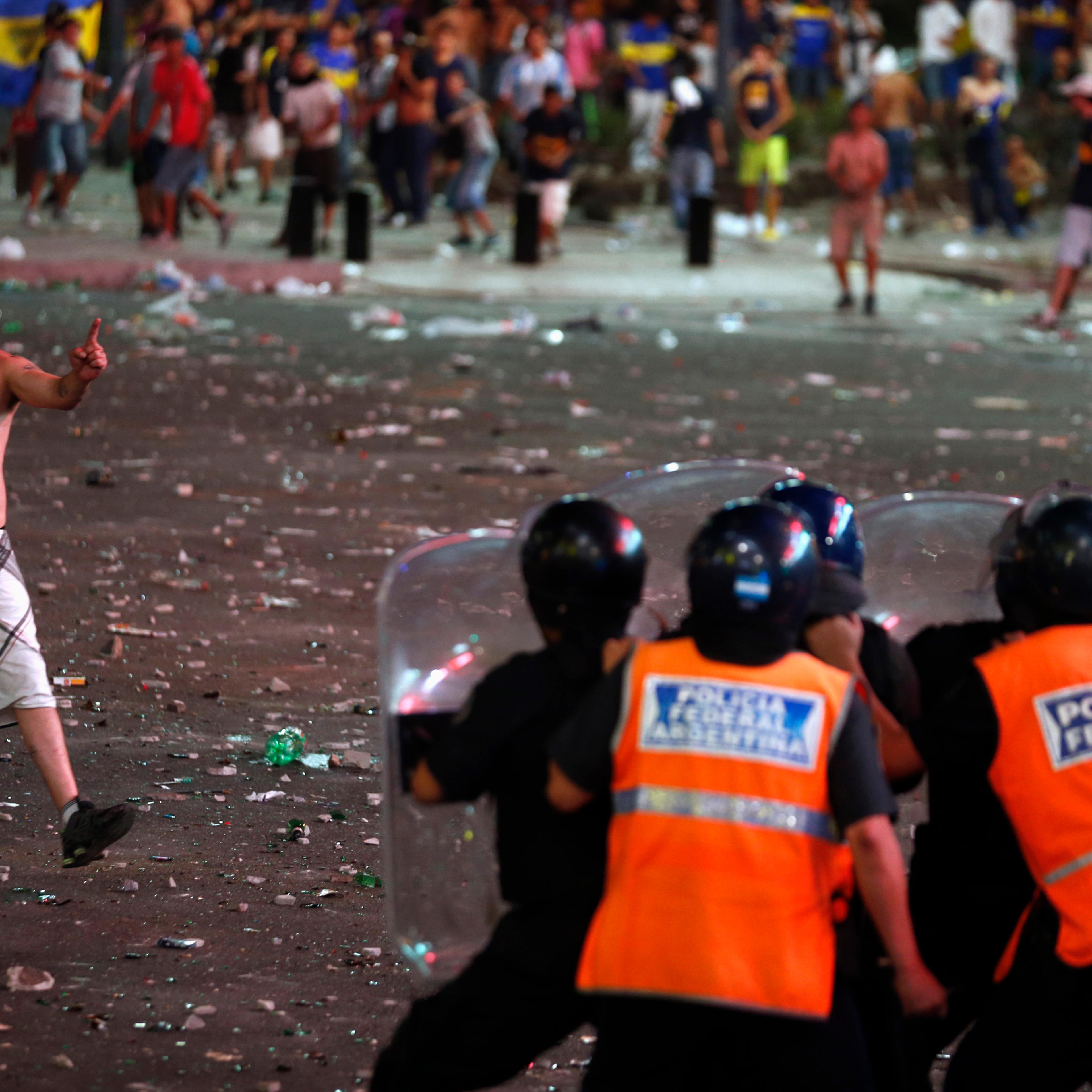 A fan of Argentine soccer team Boca Juniors confronts police during riots after celebrations of Boca Juniors Fan Day in Buenos Aires
