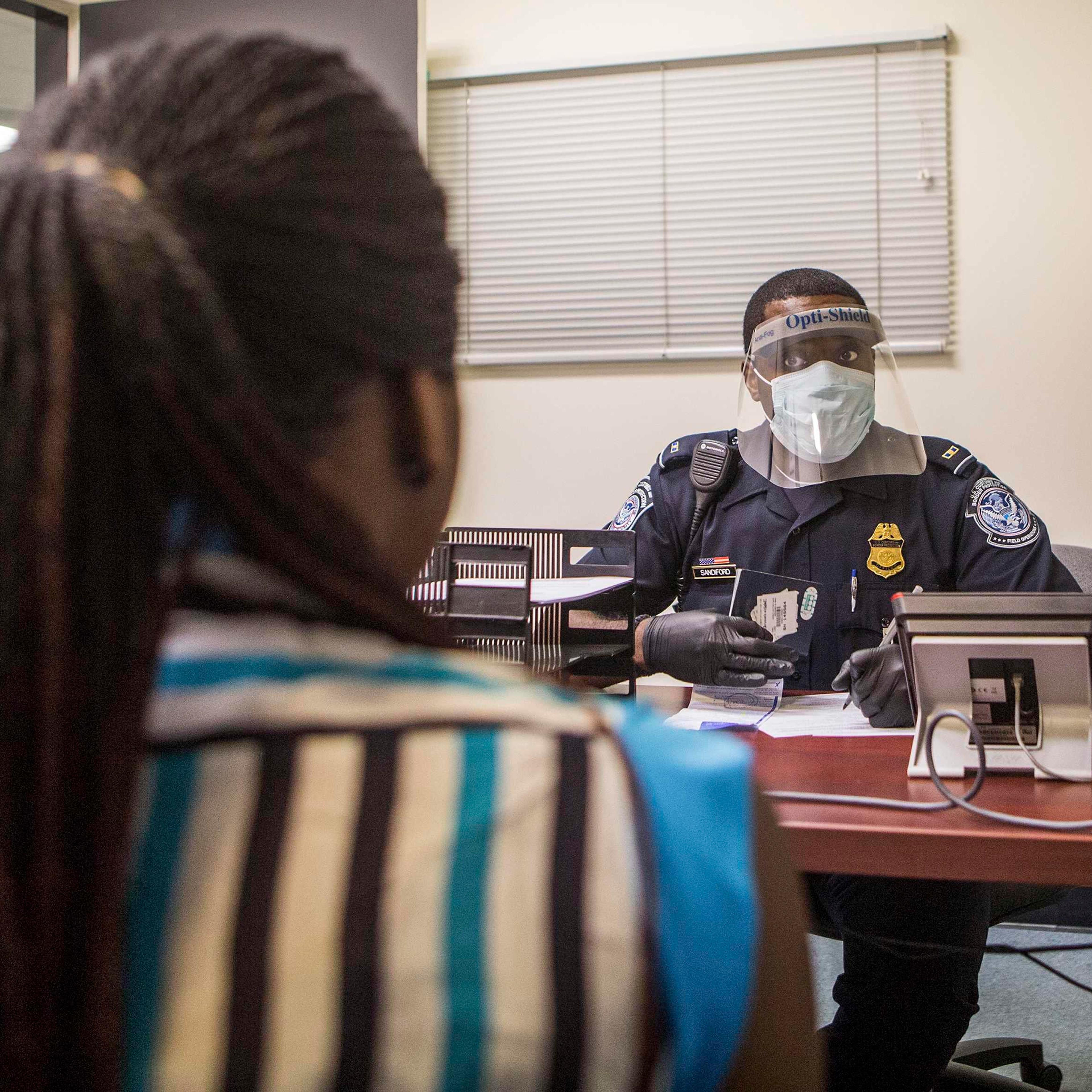 An Office of Field Operations Officer conducts an interview with a passenger at Washington Dulles International Airport