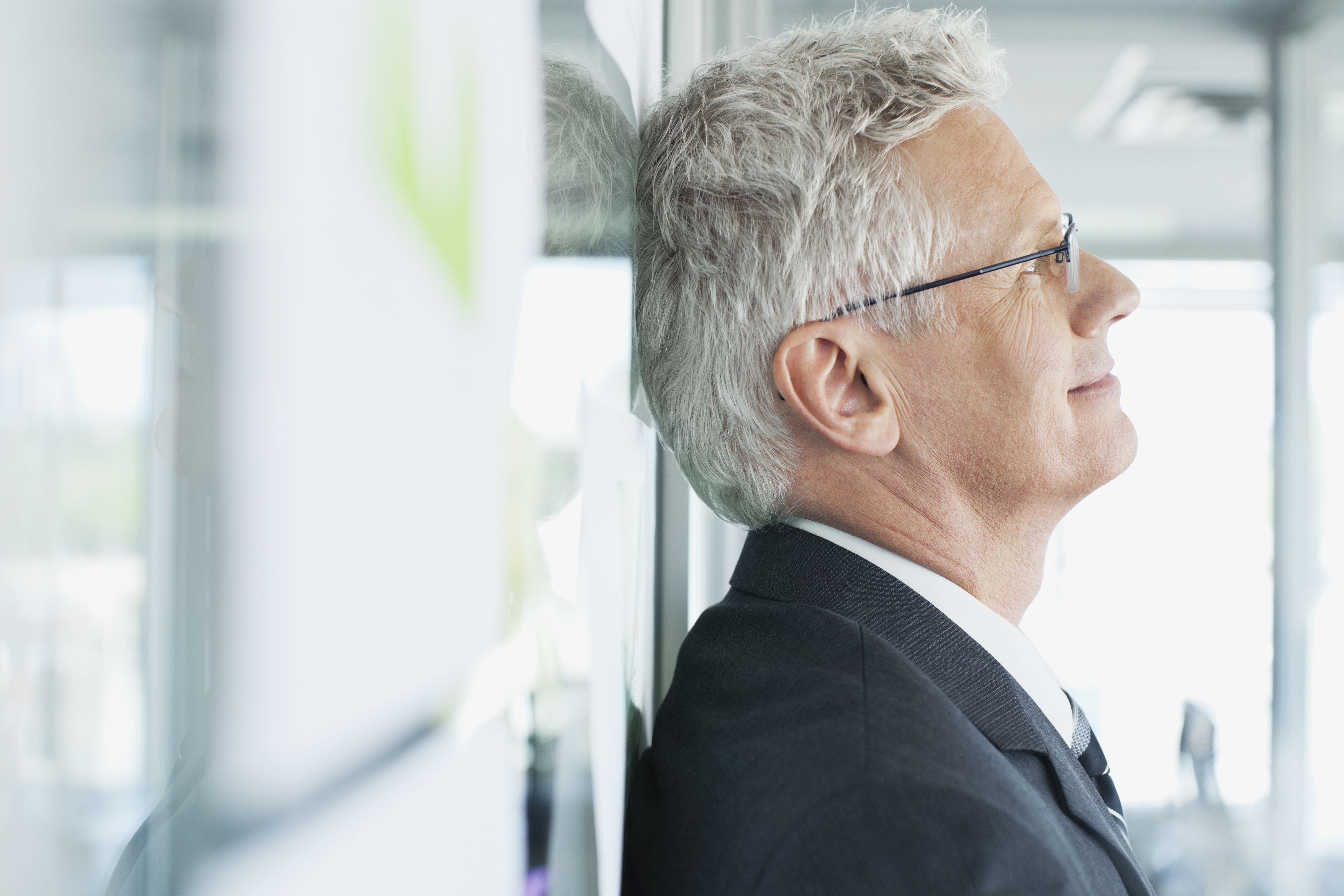 businessman-leaning-wall-smiling