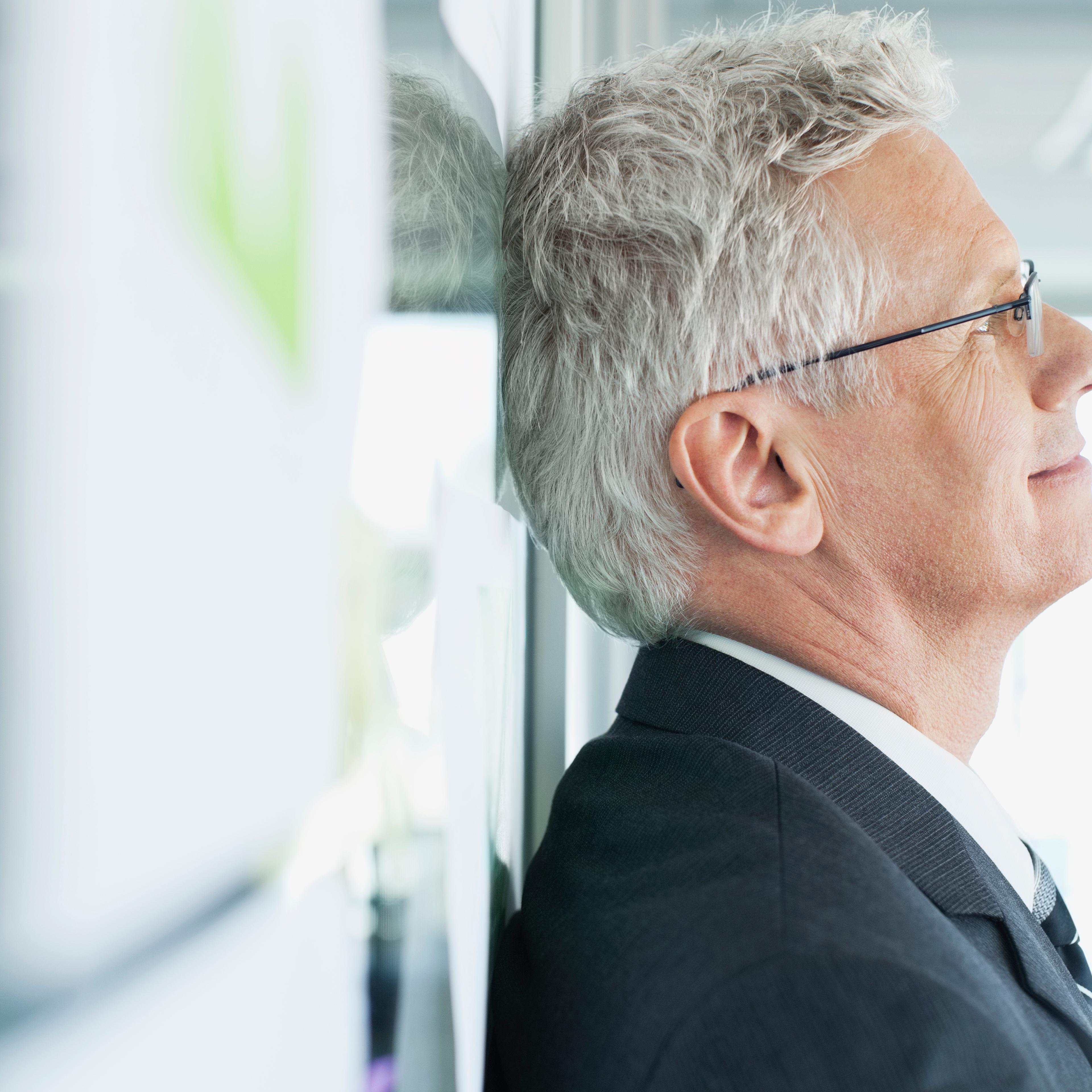 businessman-leaning-wall-smiling