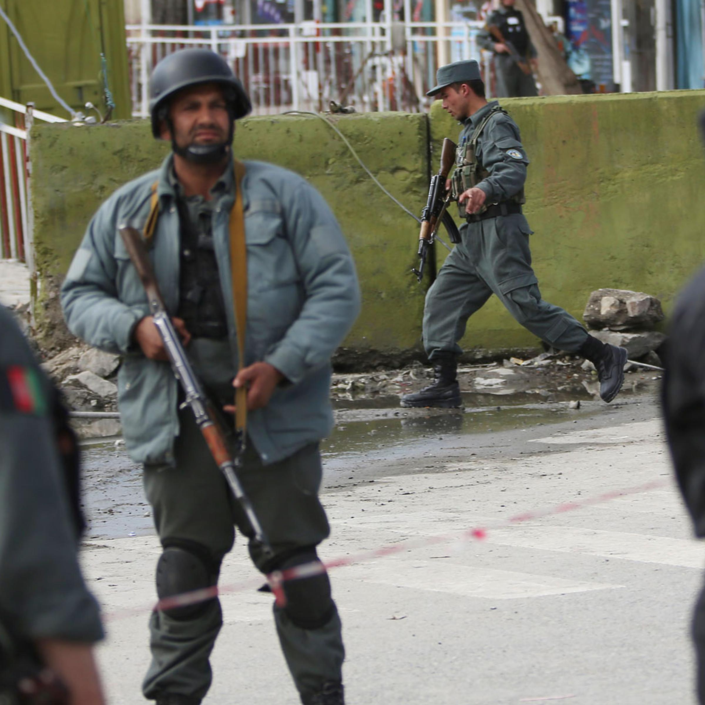 Afghan police men block the street after a suicide bomber wearing a military uniform struck the entrance gate of the Interior Ministry compound in Kabul, April 2, 2014.