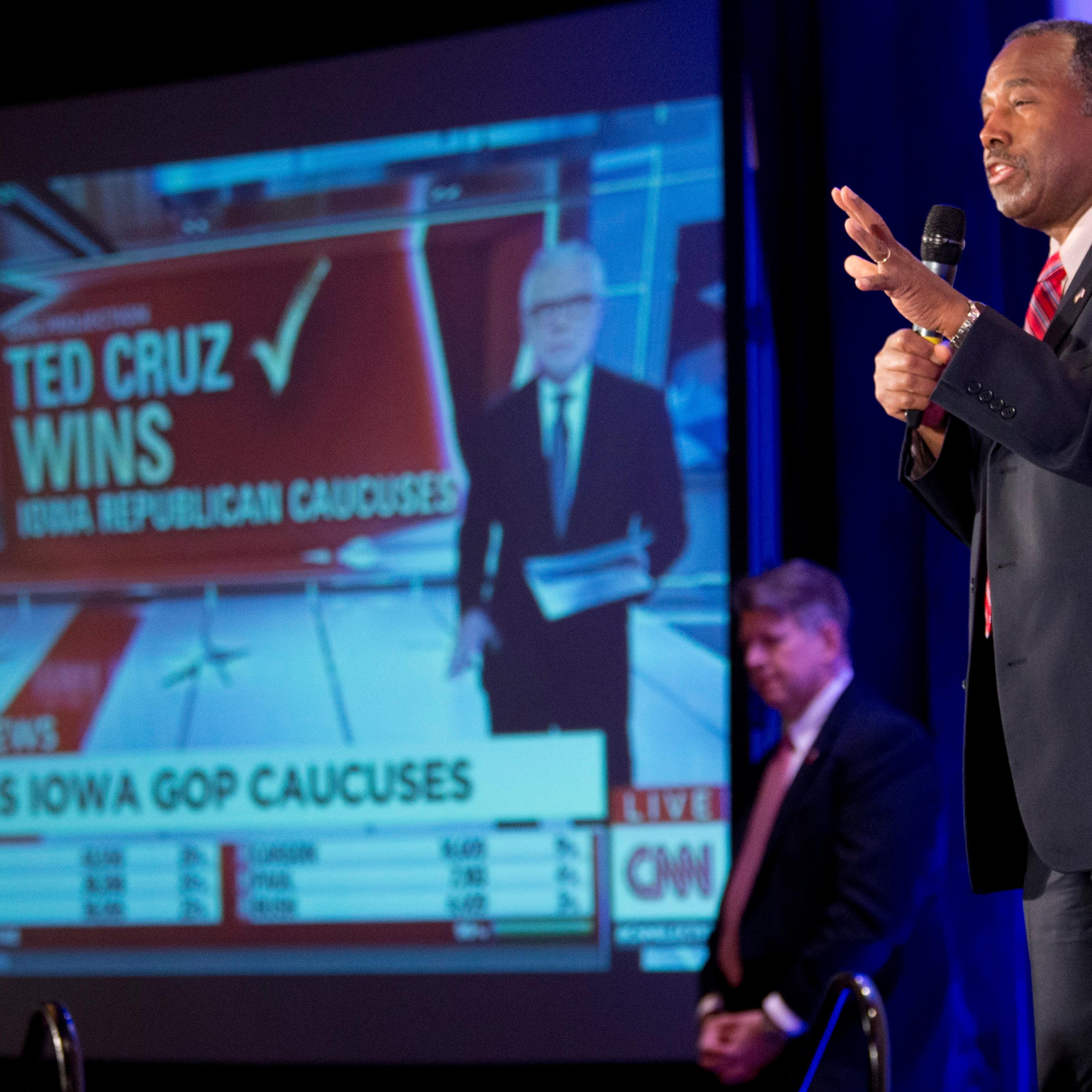 Ben Carson speaks to supporters at his campaign's Caucus Night Rally, Monday, Feb. 1, 2016, in West Des Moines, Iowa as a video screen shows a headline reporting Sen. Ted Cruz, R-Texas, the winner of the Iowa Caucus as Republican presidential candidate.