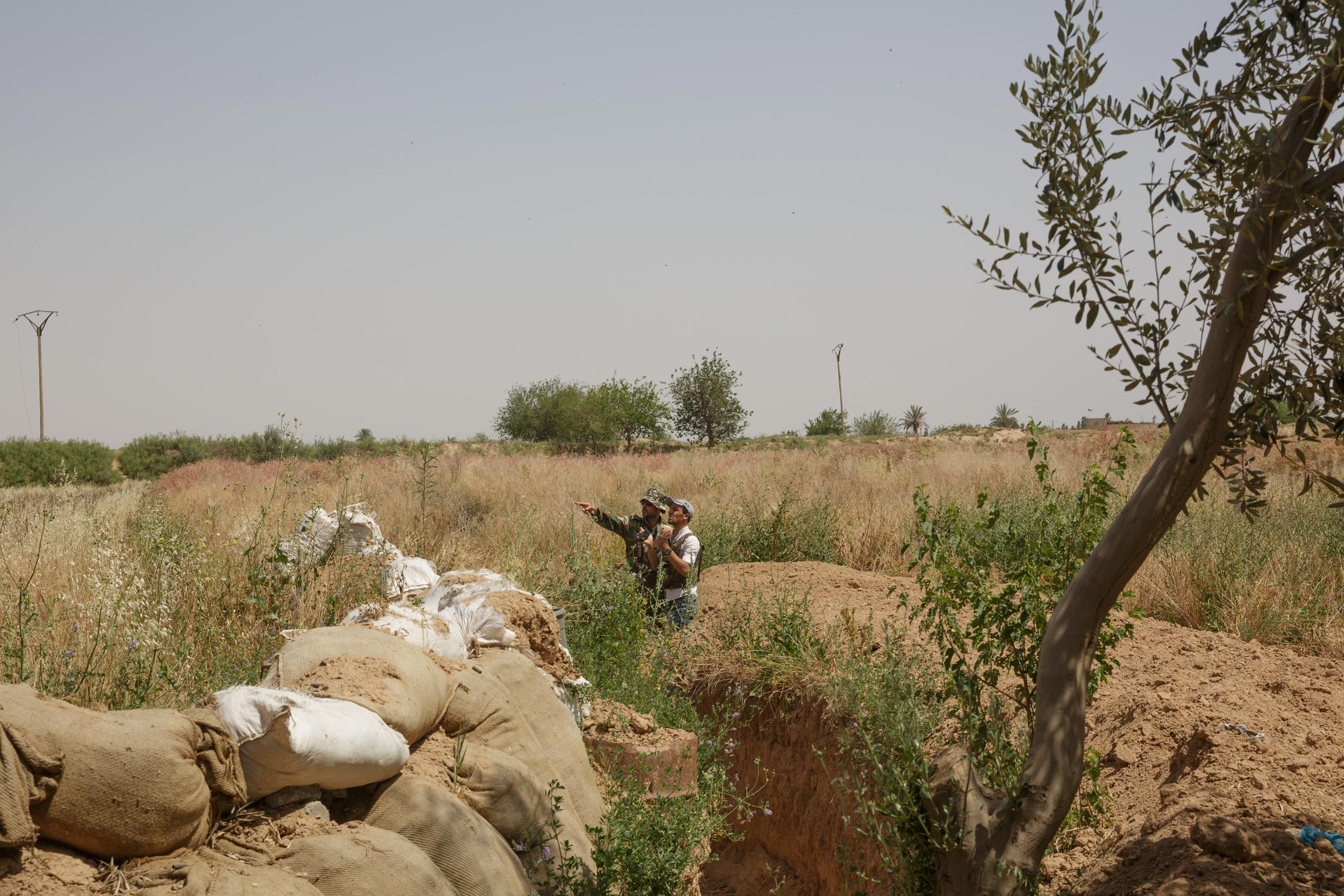 A Syrian military officer points out a nearby ISIS position on the outskirts of the besieged city of Deir-ez Zor, May 22, 2015.