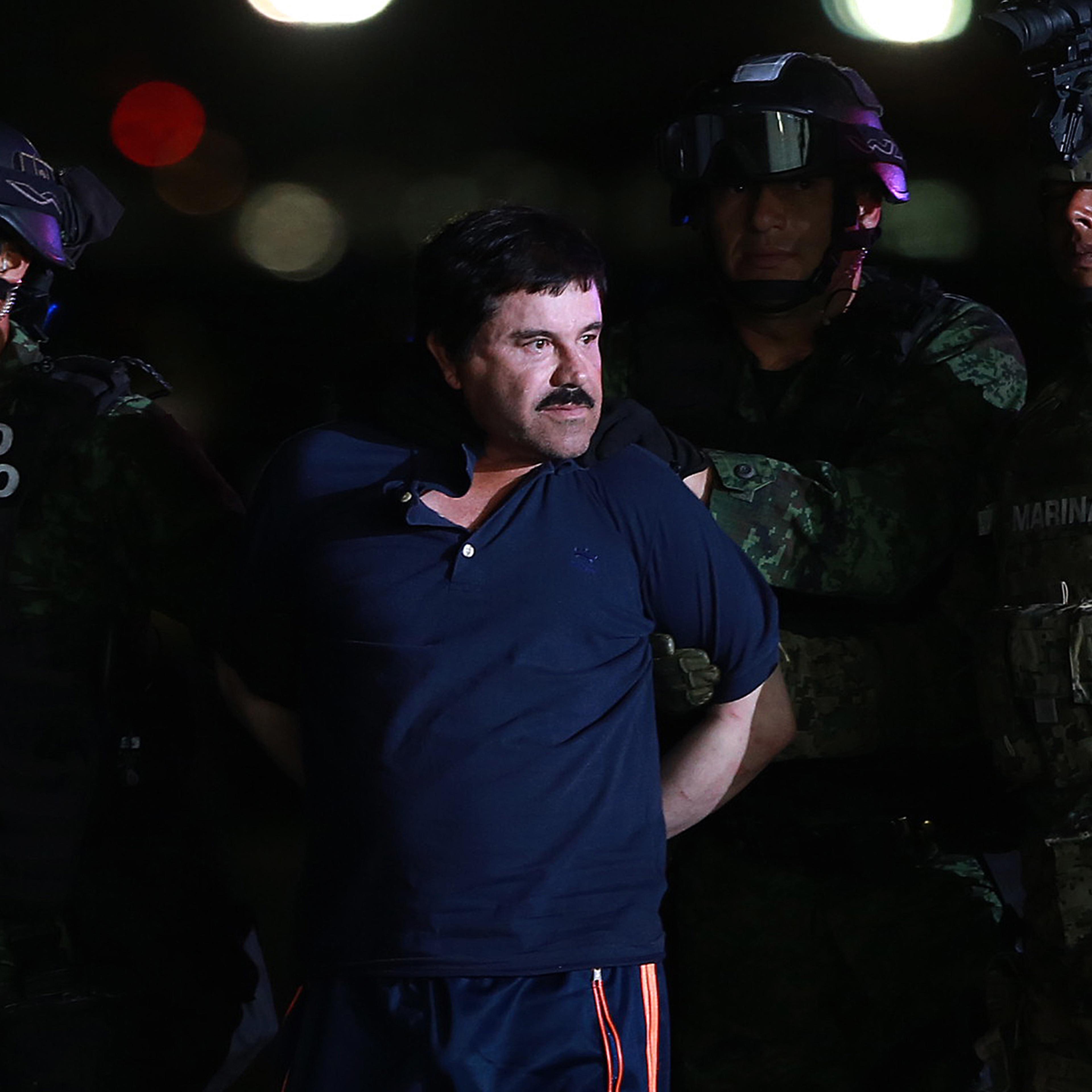 Joaquin Guzman, the world's most wanted-drug trafficker, center, is escorted by Mexican security forces at a Navy hangar in Mexico City, Mexico, on Jan. 8, 2016.