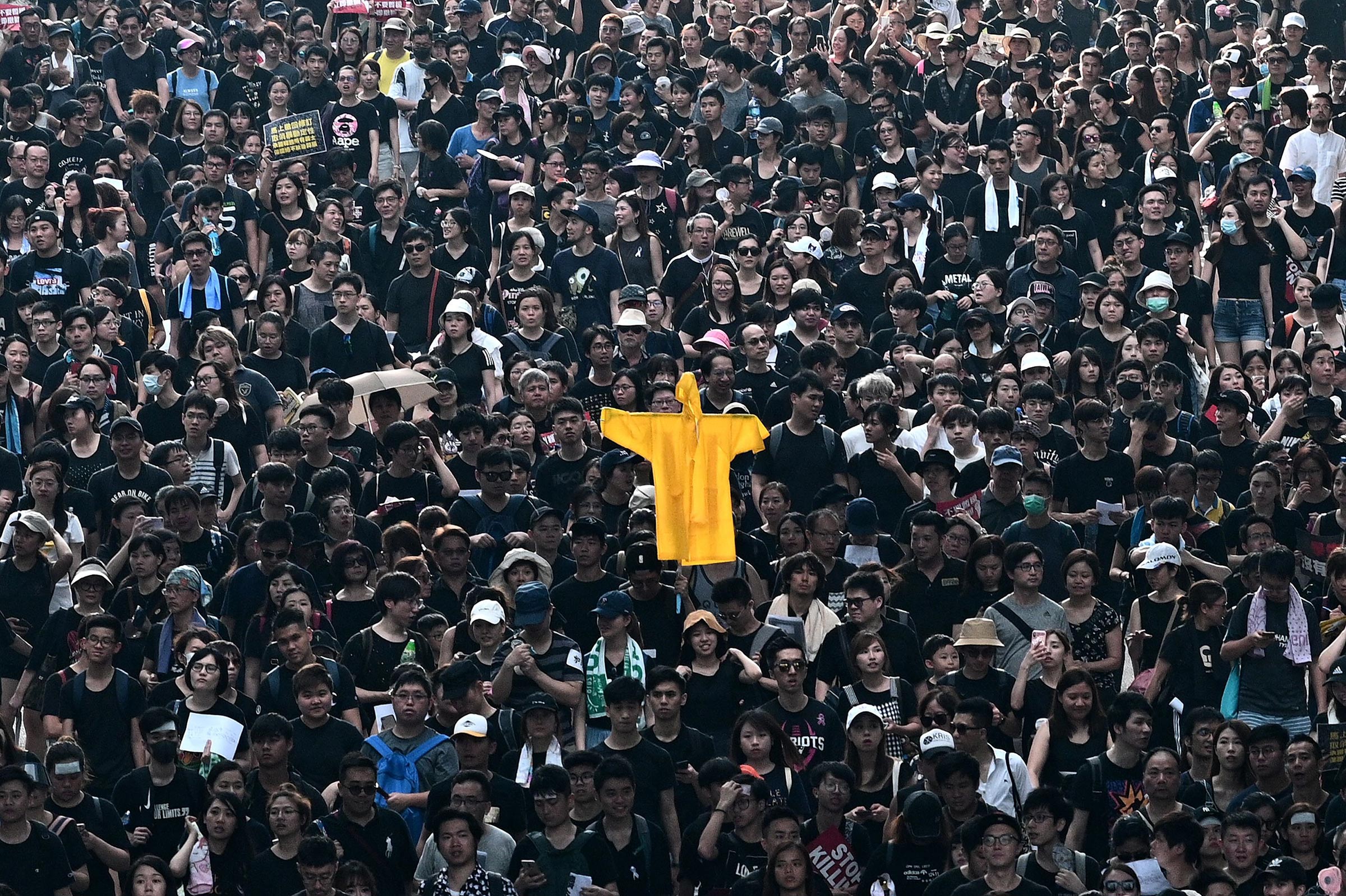 Hong Kong protesters hold up a coat on June 16 in memory of a man who died at an earlier rally.