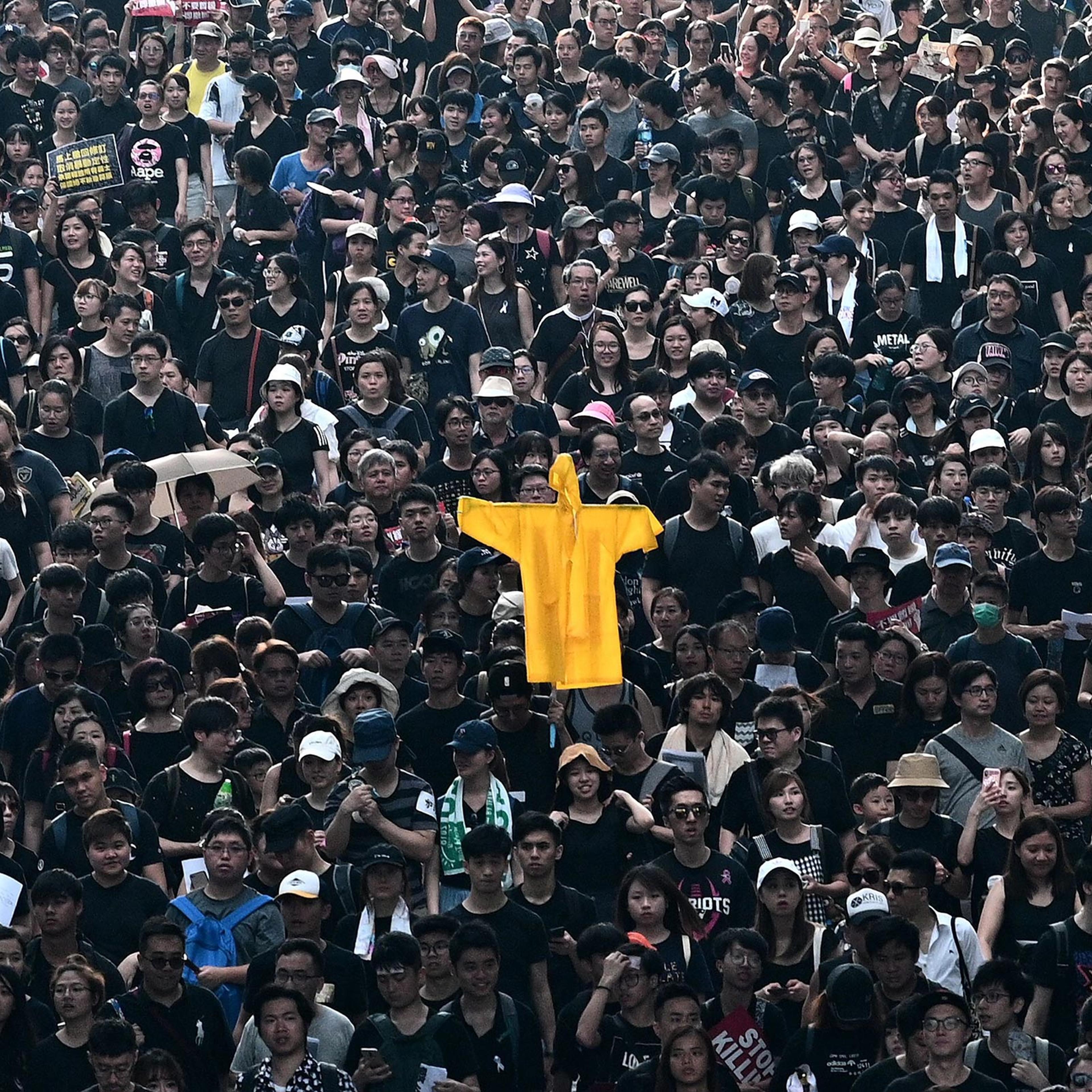 Hong Kong protesters hold up a coat on June 16 in memory of a man who died at an earlier rally.