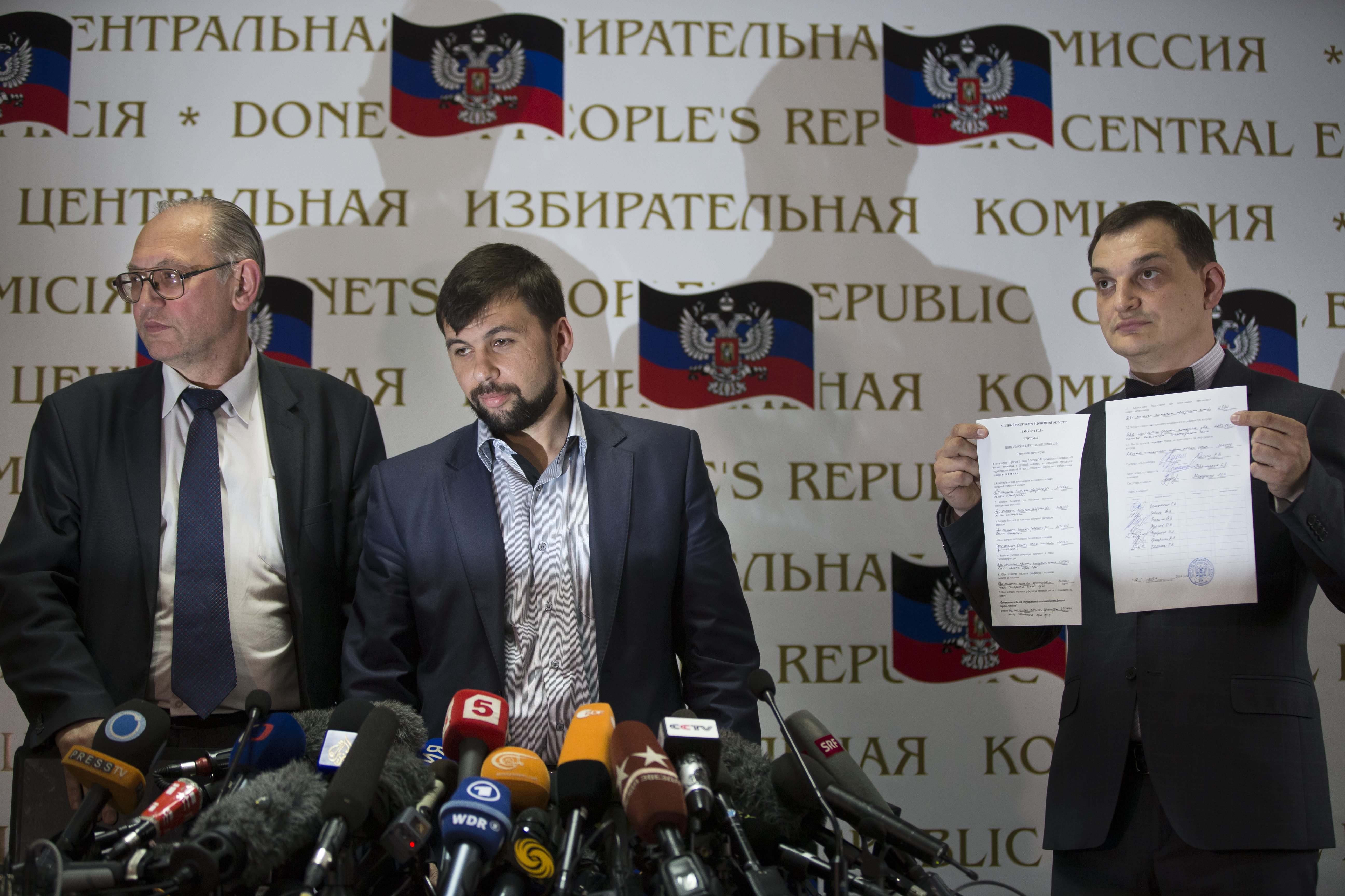 Co-chairman of the Presidium of the People's Republic of Donetsk Boris Litvinov, left, Insurgent leader head of the elections commission of the so-called Donetsk People's Republic Denis Pushilin, and vote-counter Roman Lyagin, right, show documents with 