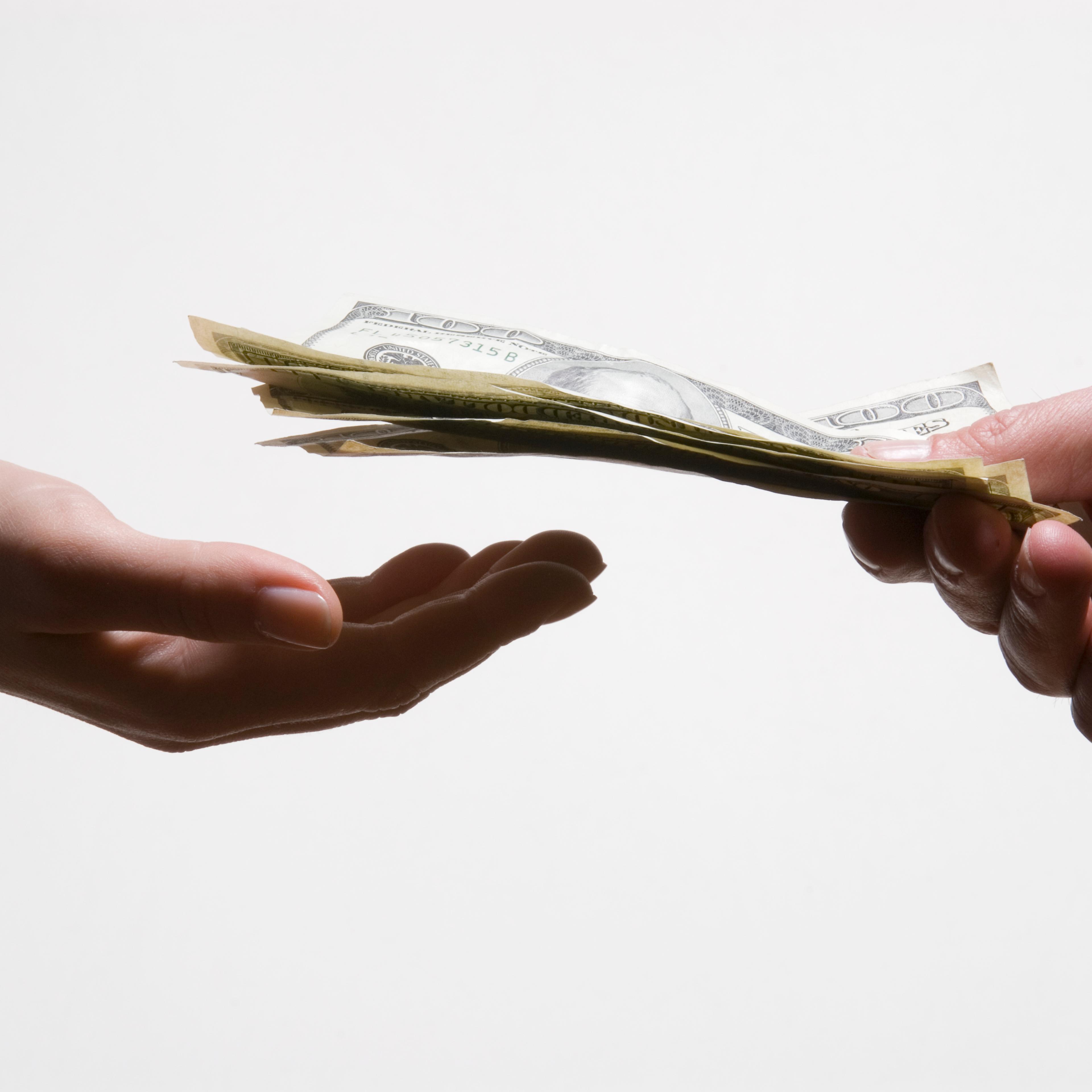 Man handing woman US dollar banknotes, close-up