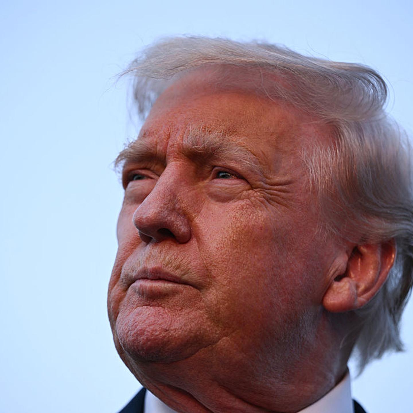 Donald Trump looking contemplatively to the right as he speaks to reporters