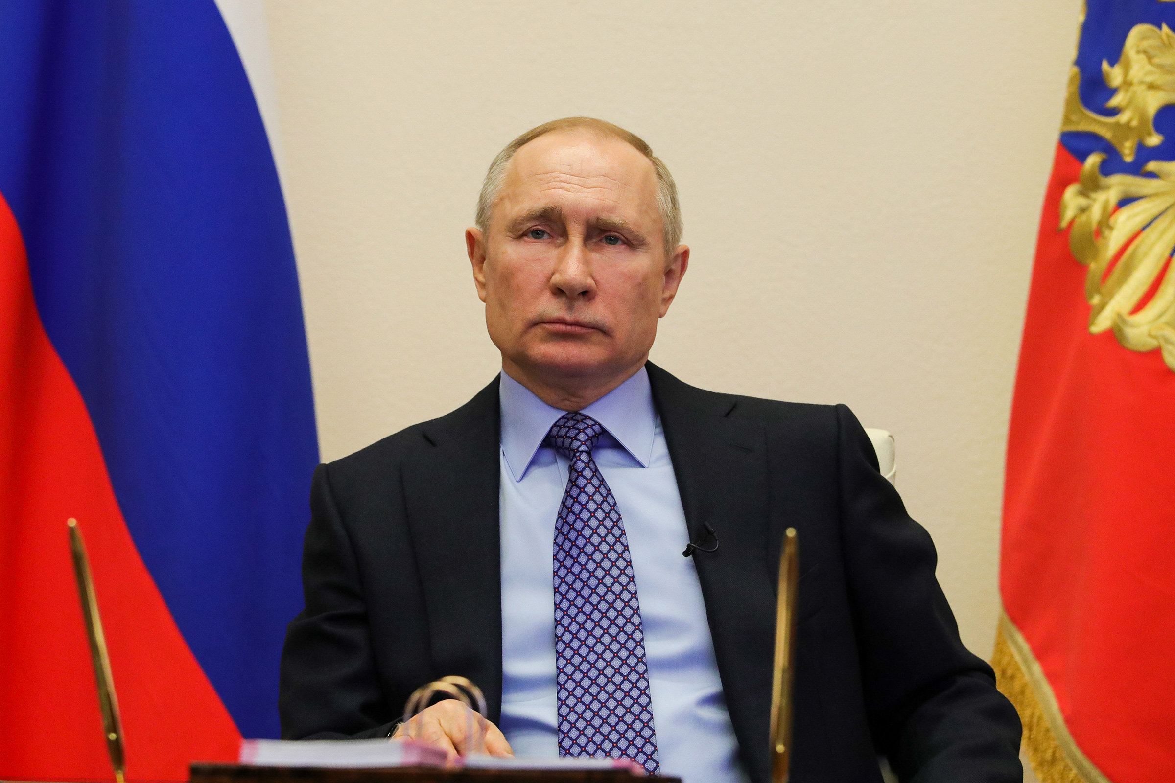 Vladimir Putin attends a meeting with regional officials via tele link in his residence on March 30