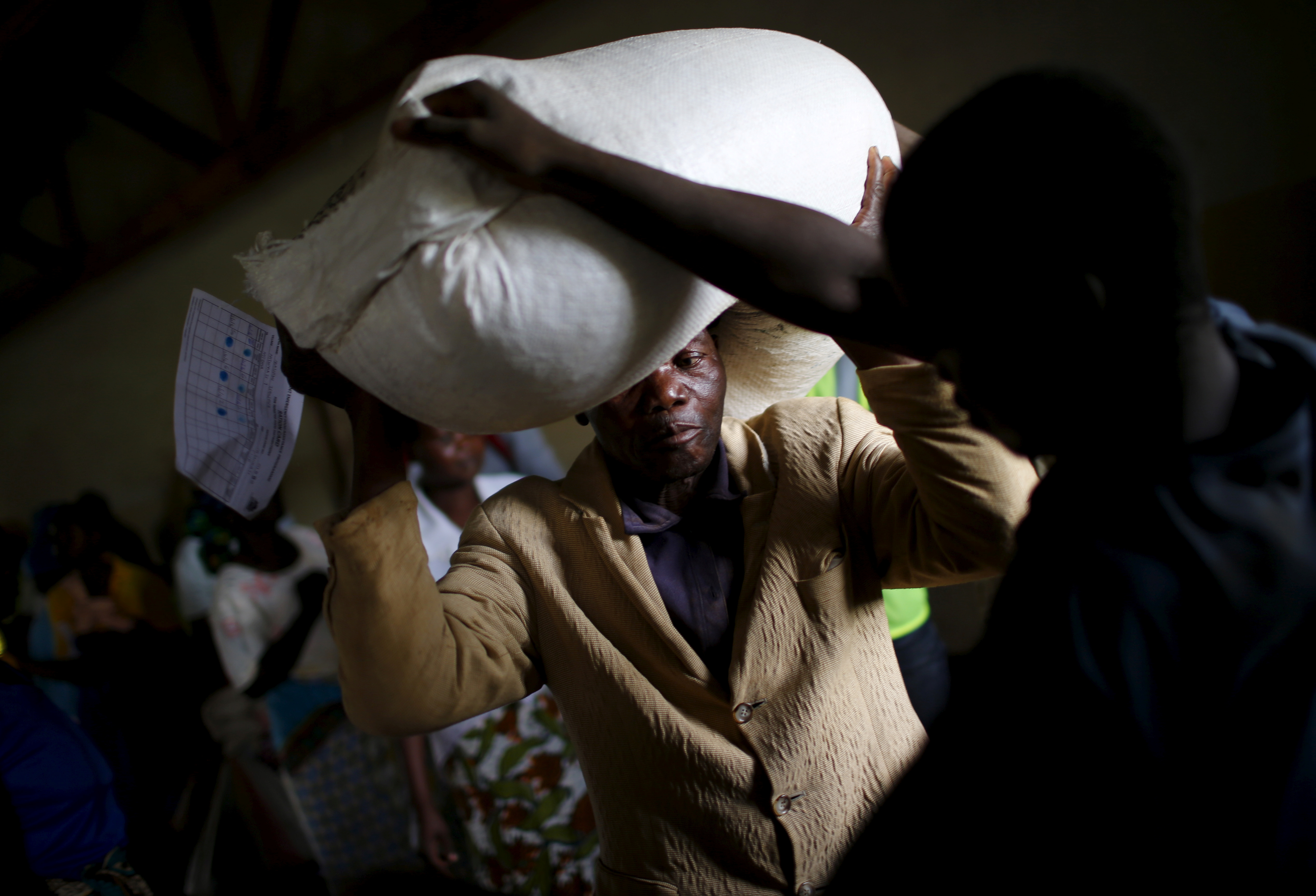 A man carries food aid distributed by the United Nations World Food Progamme (WFP) in Mzumazi village near Malawi's capital Lilongwe, Feb. 3, 2016.