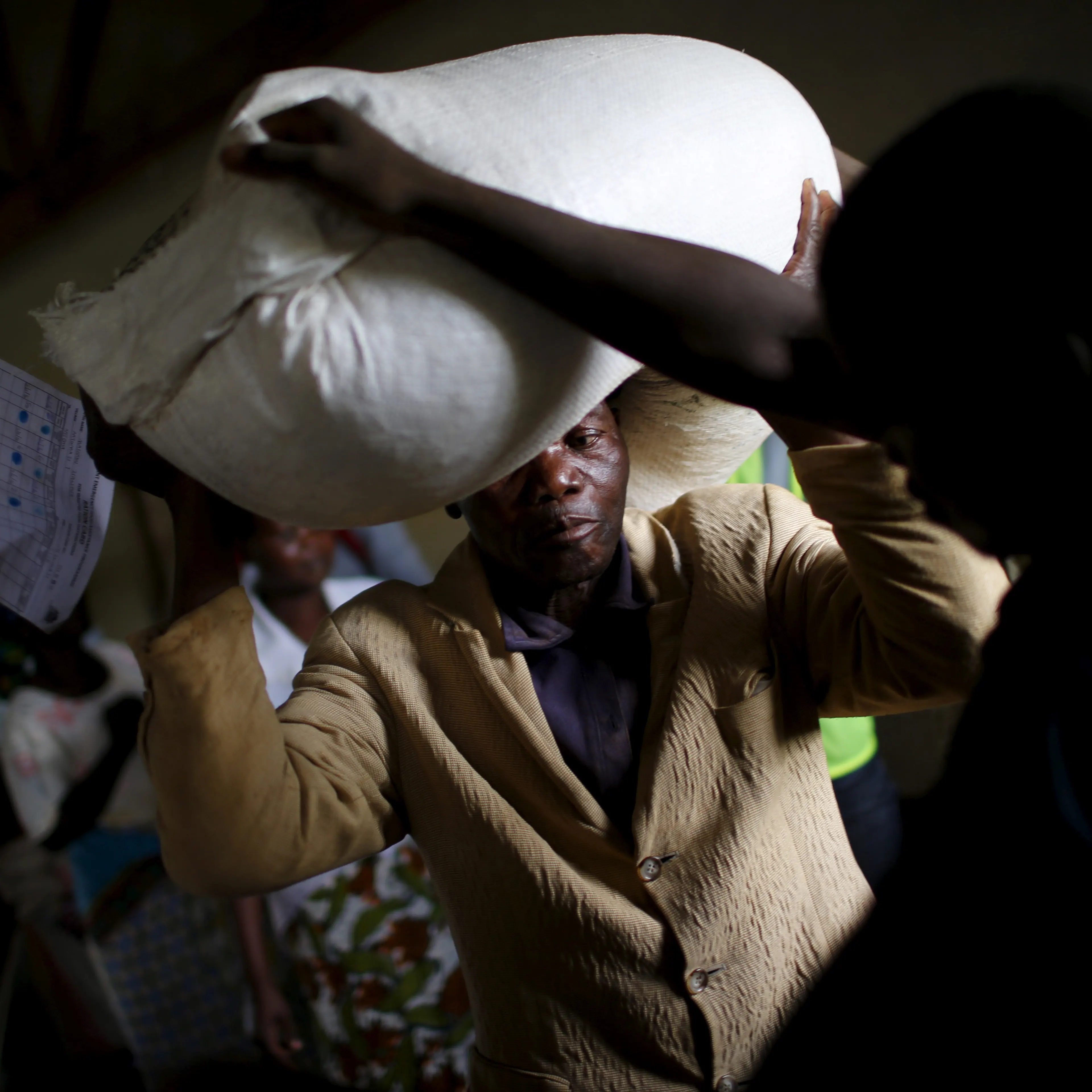 A man carries food aid distributed by the United Nations World Food Progamme (WFP) in Mzumazi village near Malawi's capital Lilongwe, Feb. 3, 2016.
