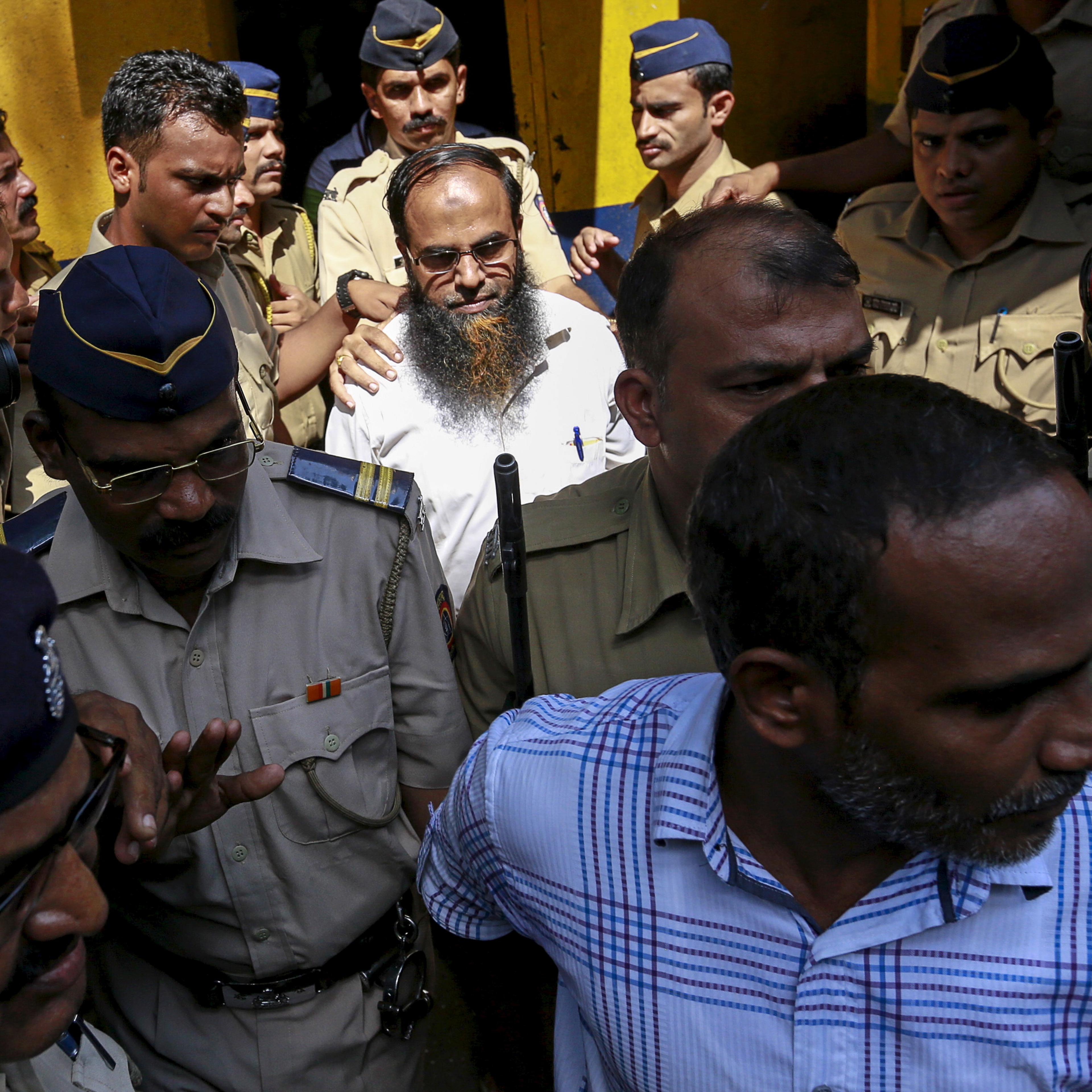Two of the 12 men, convicted of planning several blasts on crowded commuter trains in the financial capital of Mumbai in 2006, is escorted by police to a court in Mumbai