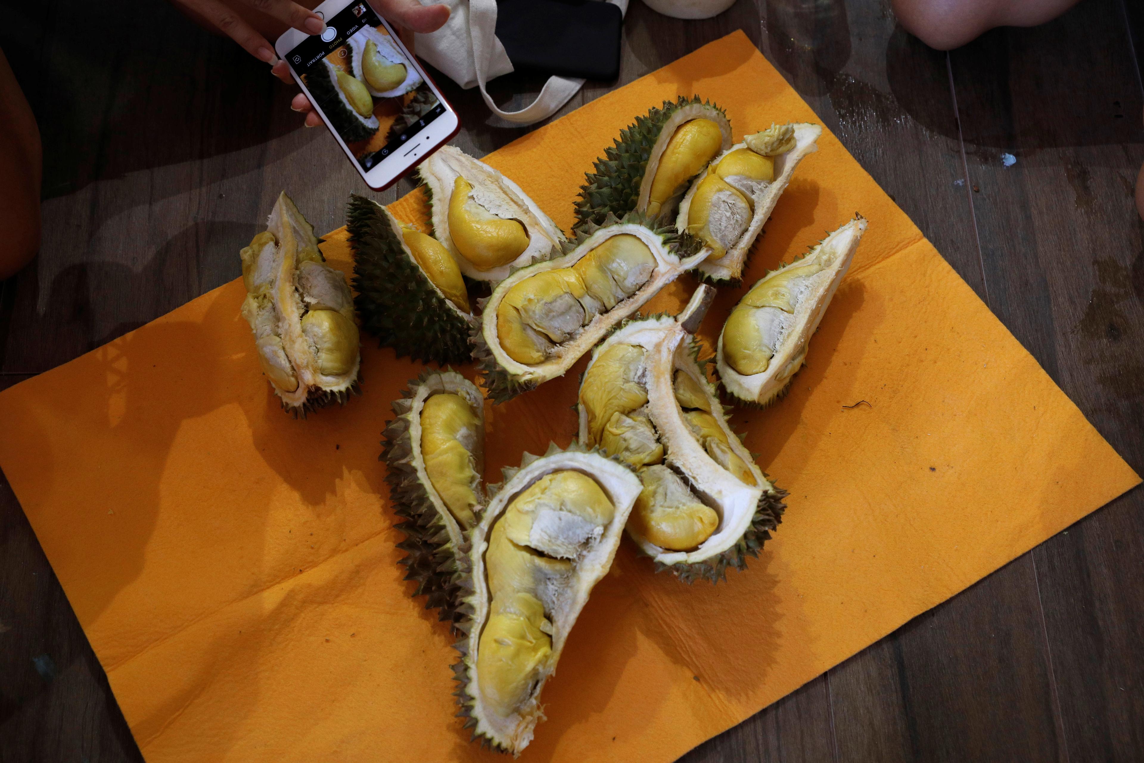Participants take photos of their durians after the Durian Run in Singapore