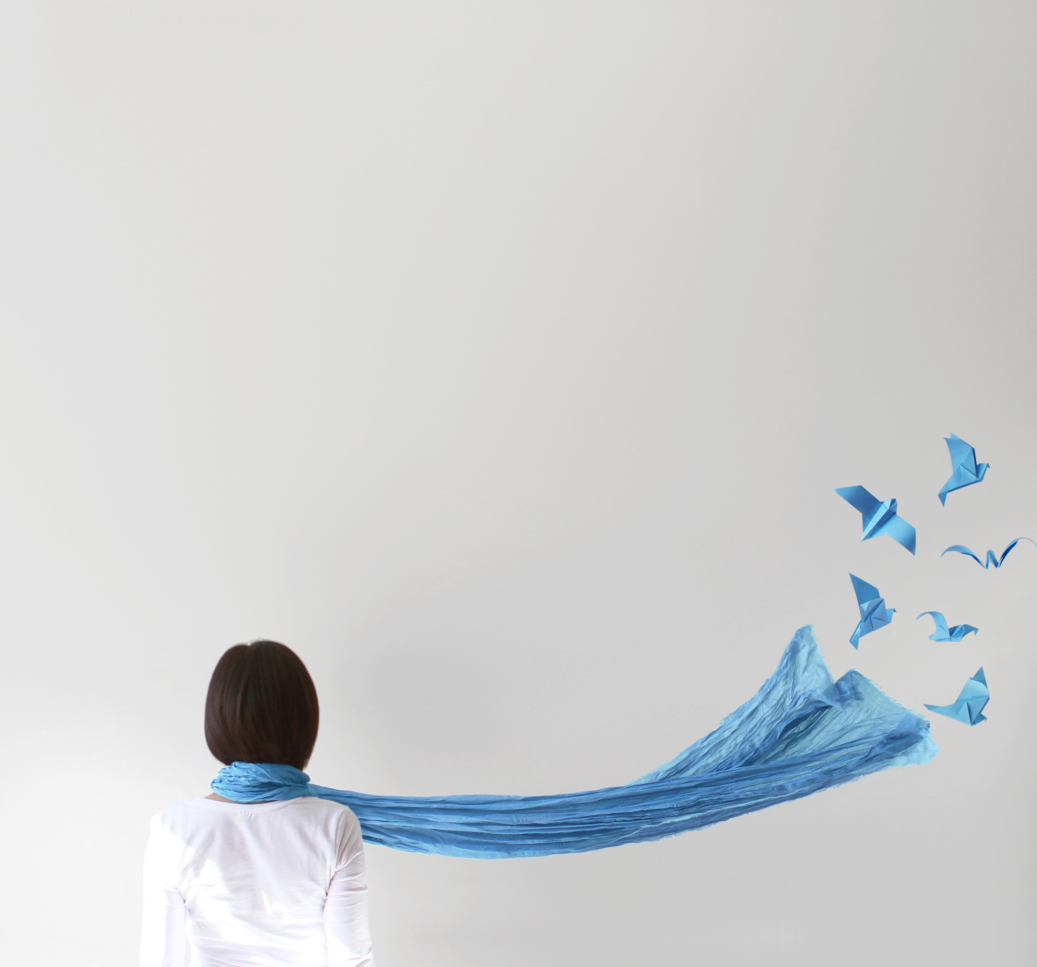 Rear view of woman with blue scarf and  origami birds