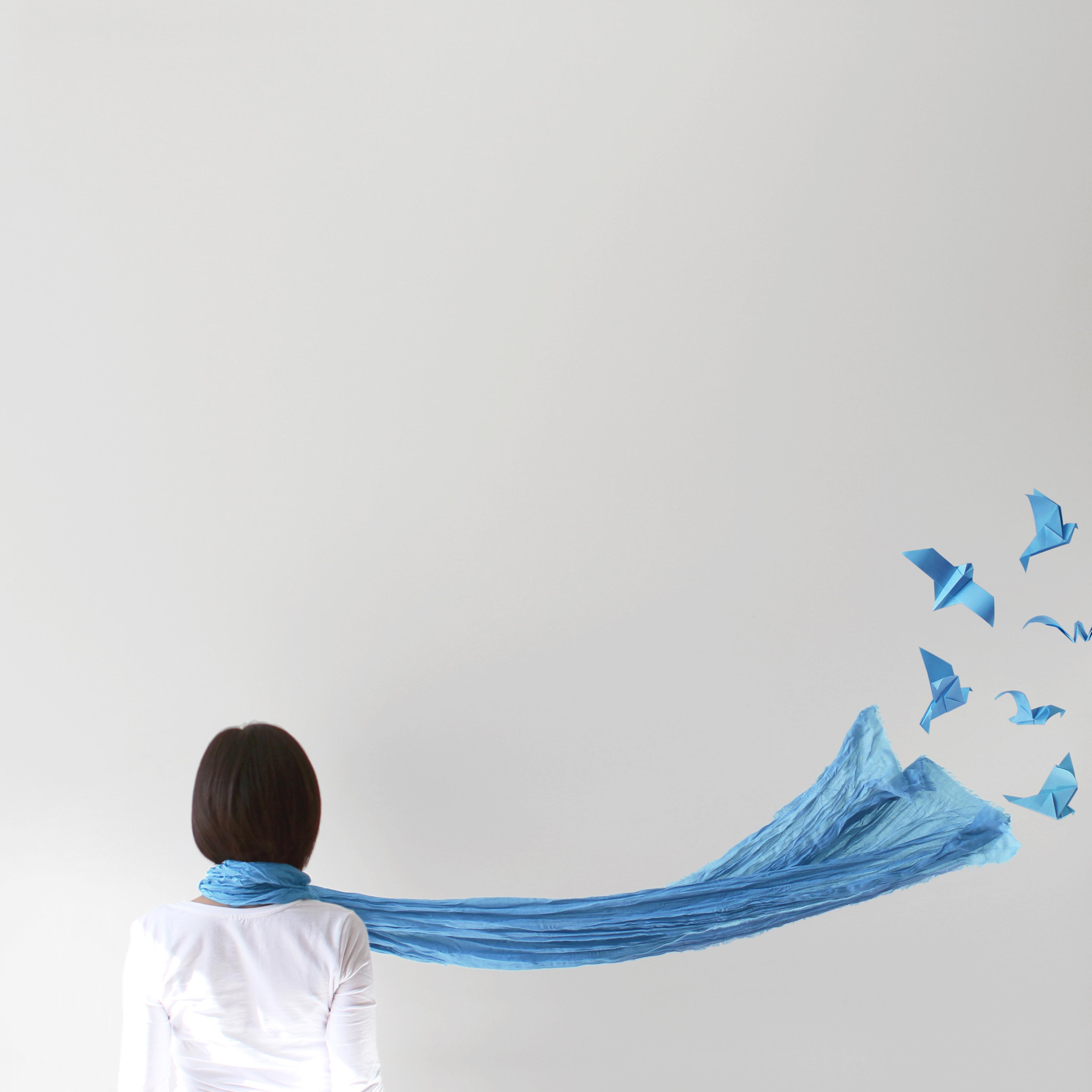 Rear view of woman with blue scarf and origami birds