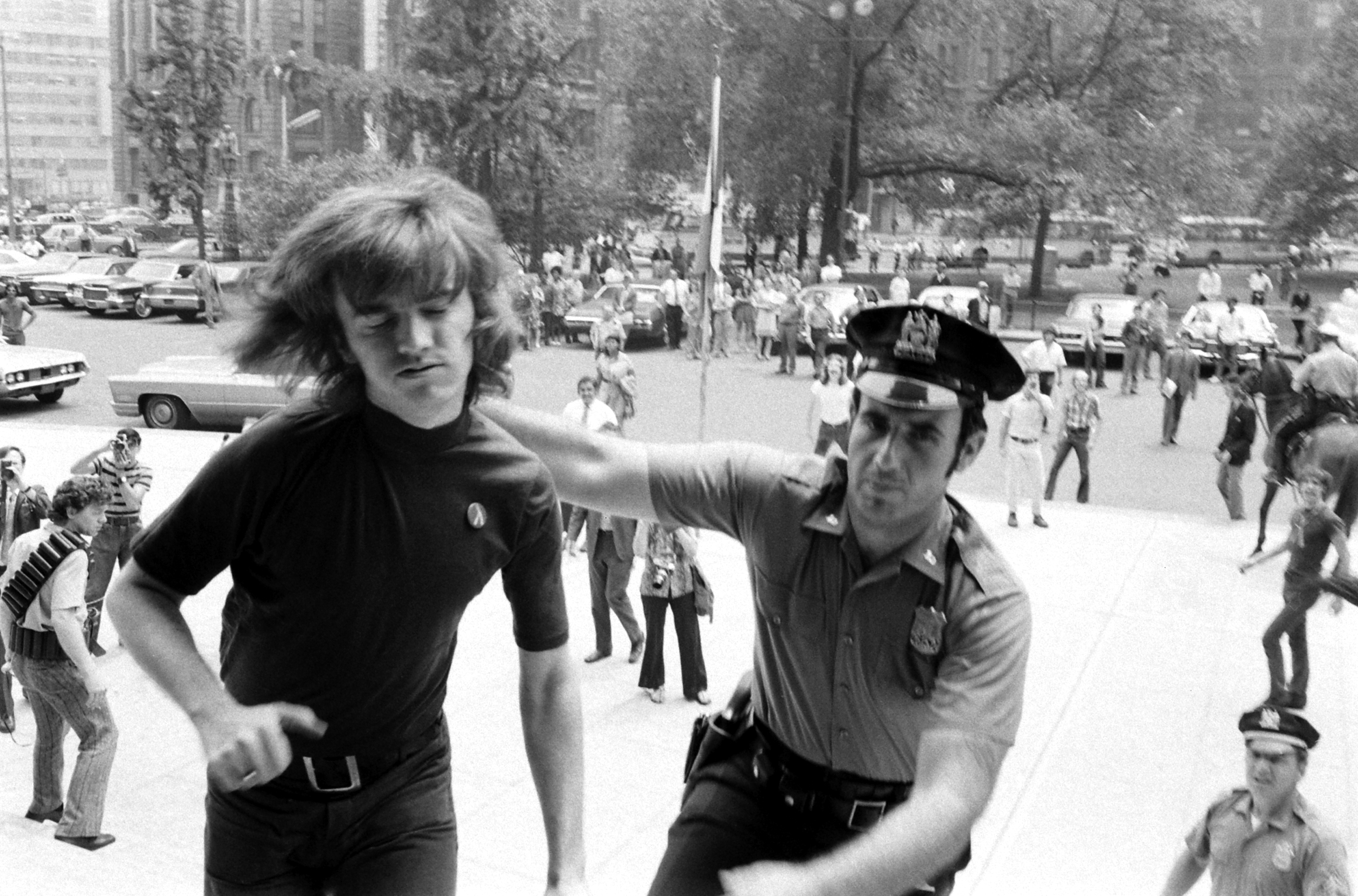Collared by a patrolman after he deliberately crossed police barricades at New York's City Hall, Gay Activists Alliance President Jim Owles submits to arrest. Members of his organization were protesting City Council reluctance to debate a fair employment