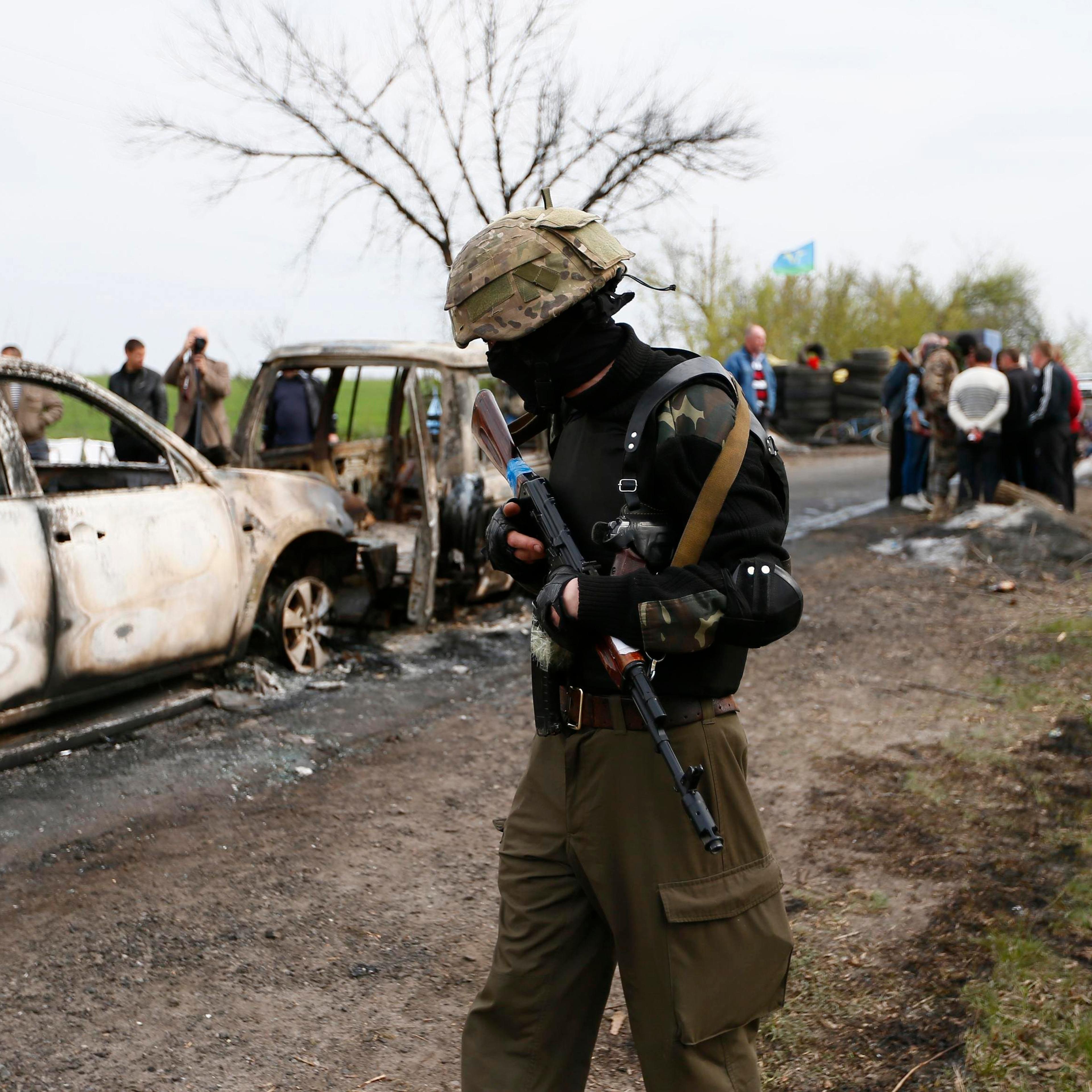 A Pro-Russian militant walks near a checkpoint that was the scene of a gunfight overnight near the city of Slaviansk, April 20, 2014.