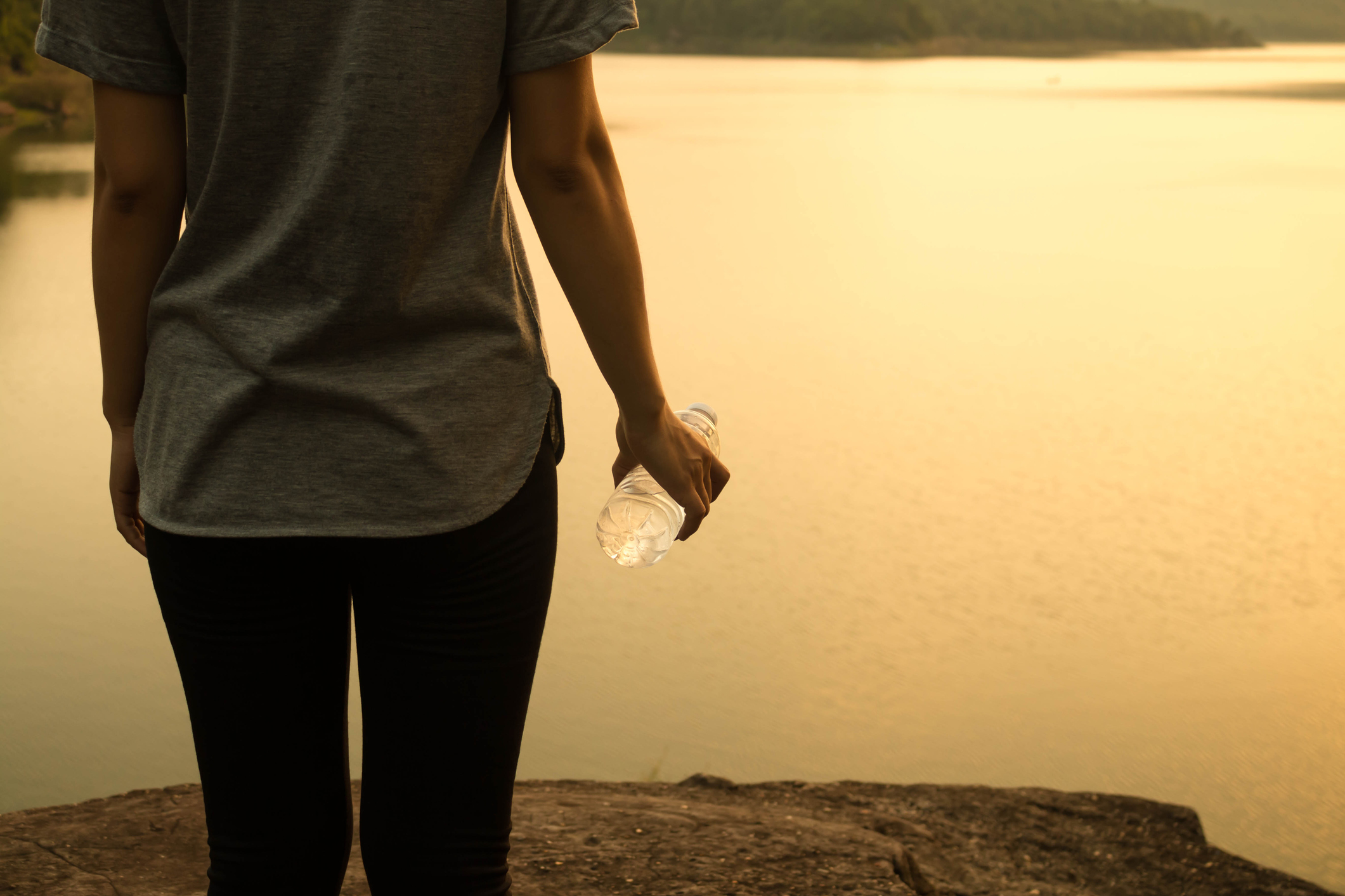 Midsection Of Woman Standing By Lake