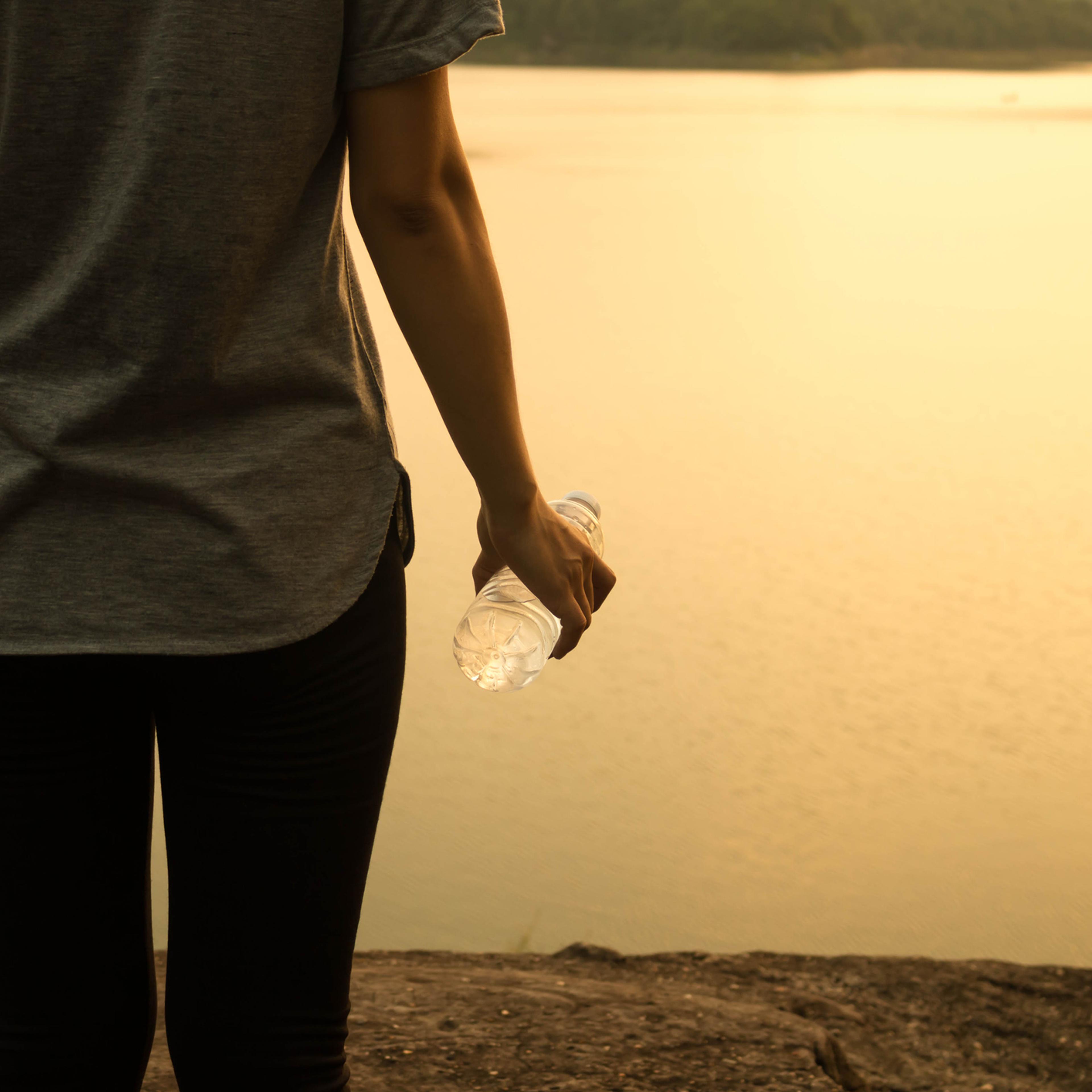 Midsection Of Woman Standing By Lake