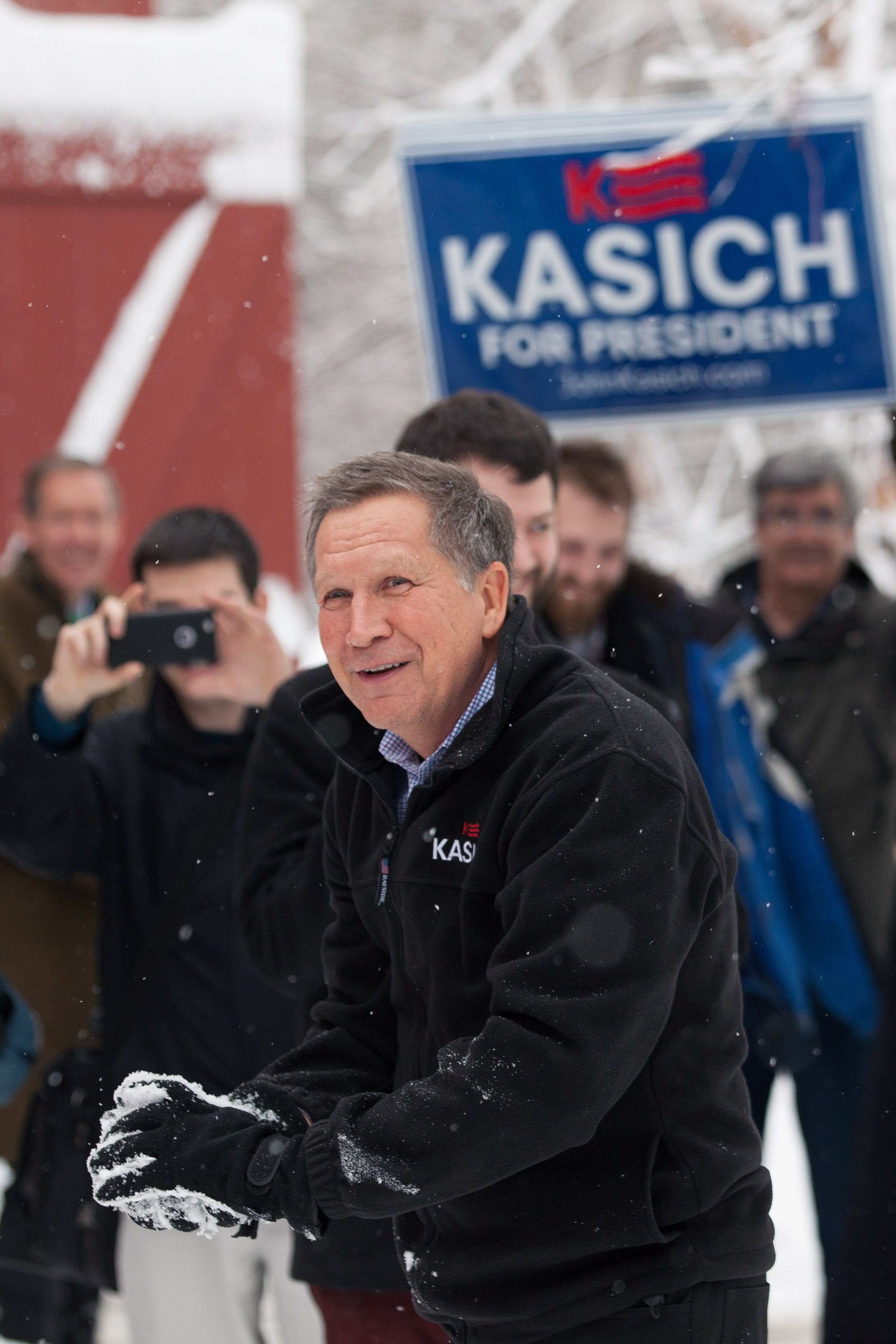 HOLLIS, NH - FEBRUARY 05: Ohio Governor and Republican presidential candidate John Kasich smiles during a snowball fight with his staff following a town hall style meeting on February 5, 2016 in Hollis, New Hampshire. Democratic and Republican Presidenti