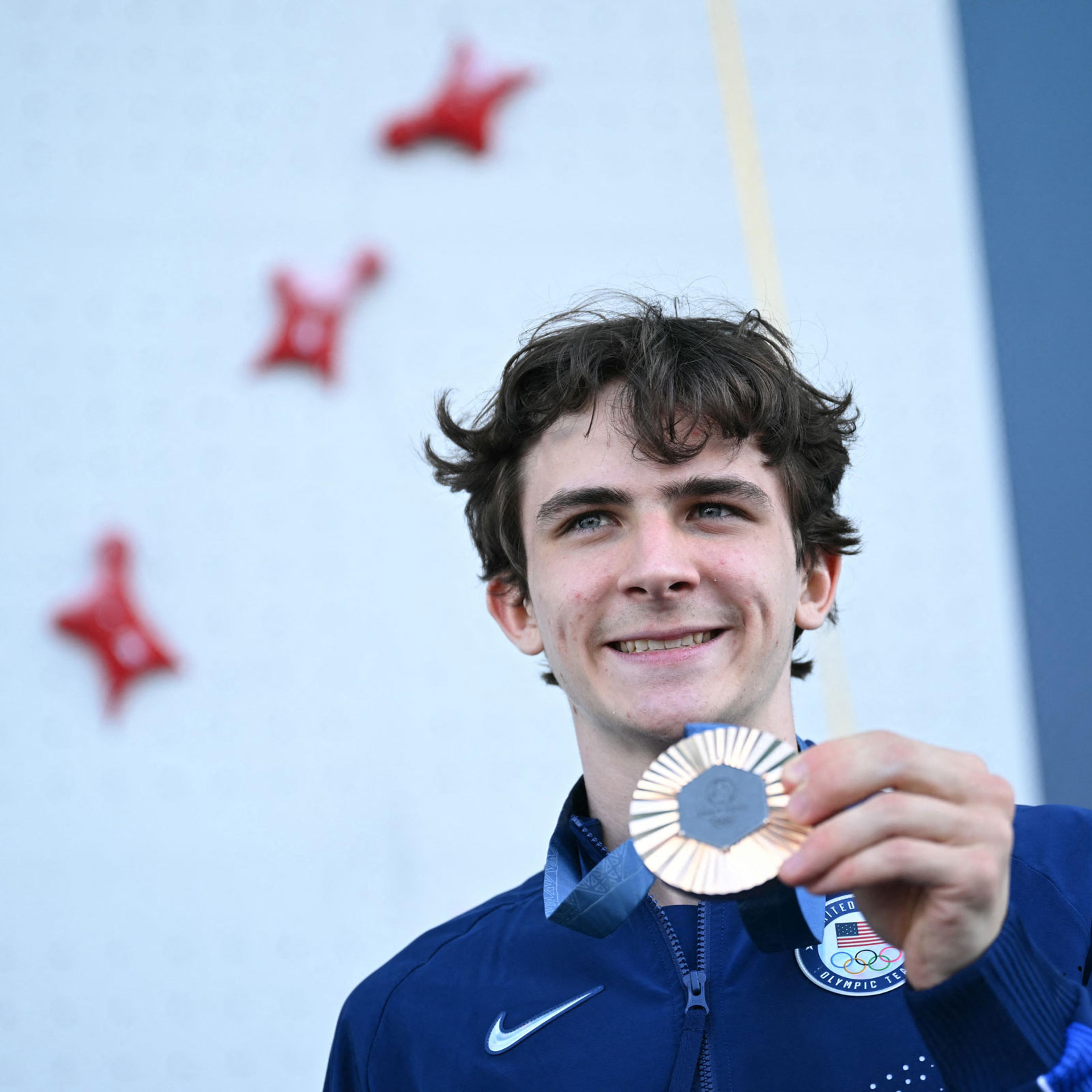 Bronze medalist Sam Watson poses on the podium of the men’s sport climbing speed event during the Paris 2024 Olympic Games on August 8, 2024.
