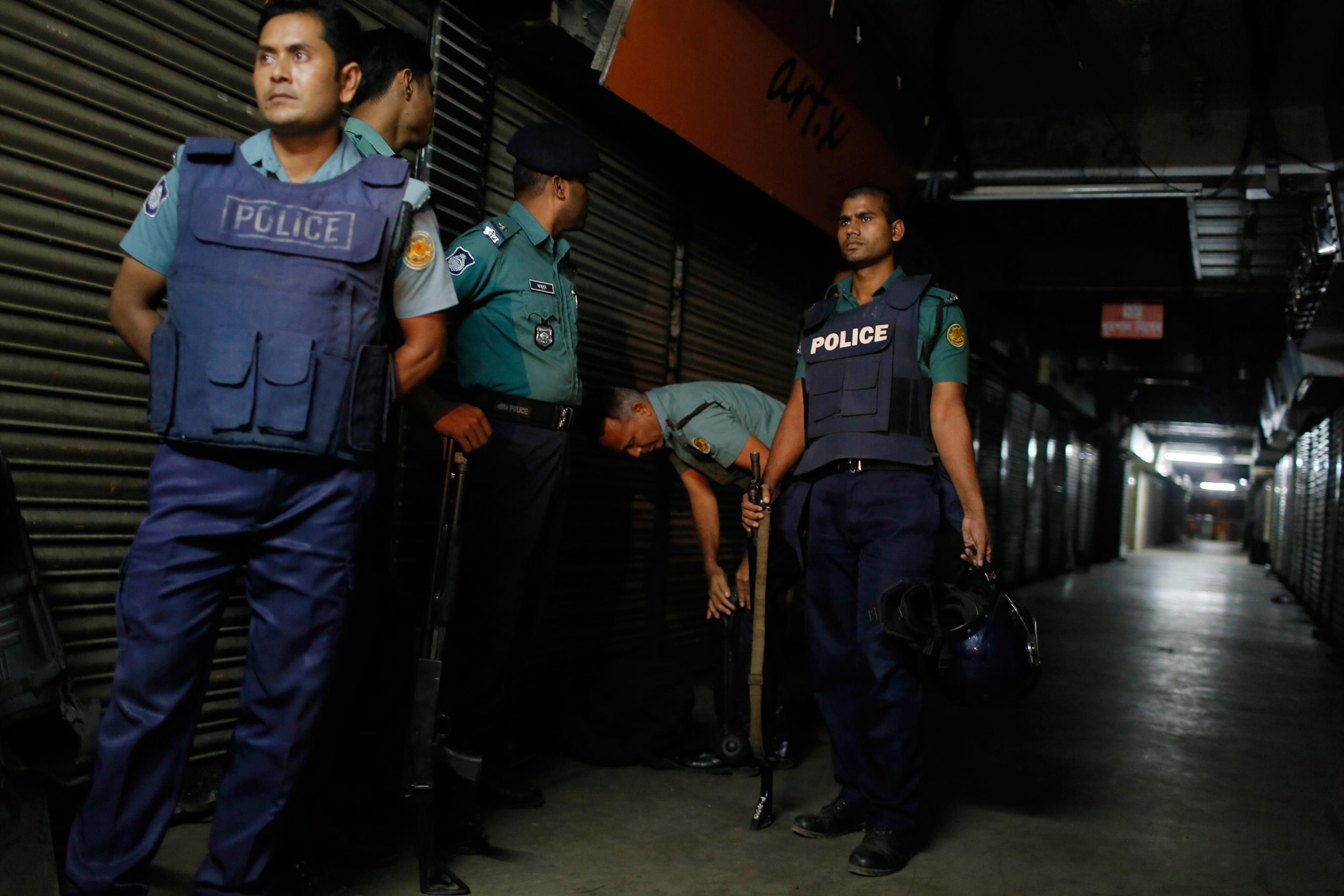 Bangladeshi security officers stand guard at the site where the slaughtered body of Faisal Arefin Deepan was found in Dhaka, Bangladesh, Saturday, Oct. 31, 2015. The publisher of secular books was hacked to death and three other people were wounded in tw