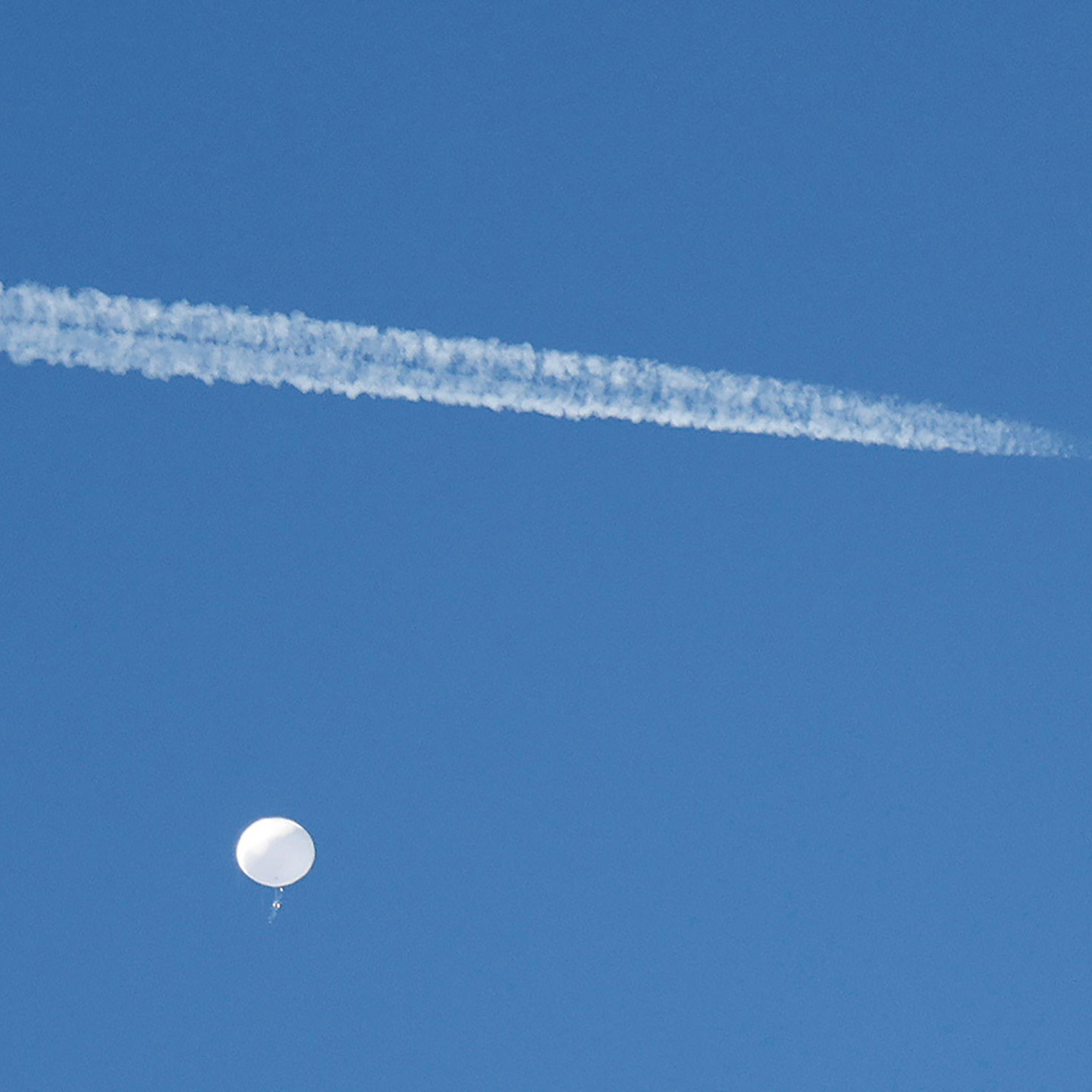 FILE PHOTO: A jet flies by a suspected Chinese spy balloon as it floats off the coast in Surfside Beach