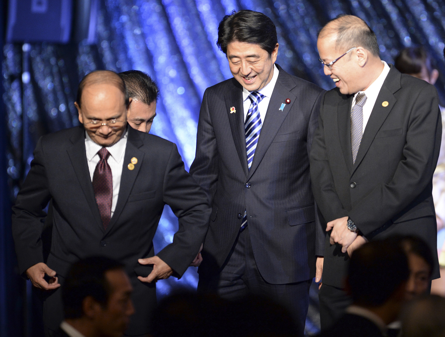 Japan's Prime Minister Shinzo Abe smiles with Myanmar's President Thein Sein and Philippine President Benigno Aquino as they leave the stage during a gala dinner of the ASEAN-Japan Commemorative Summit meeting in Tokyo