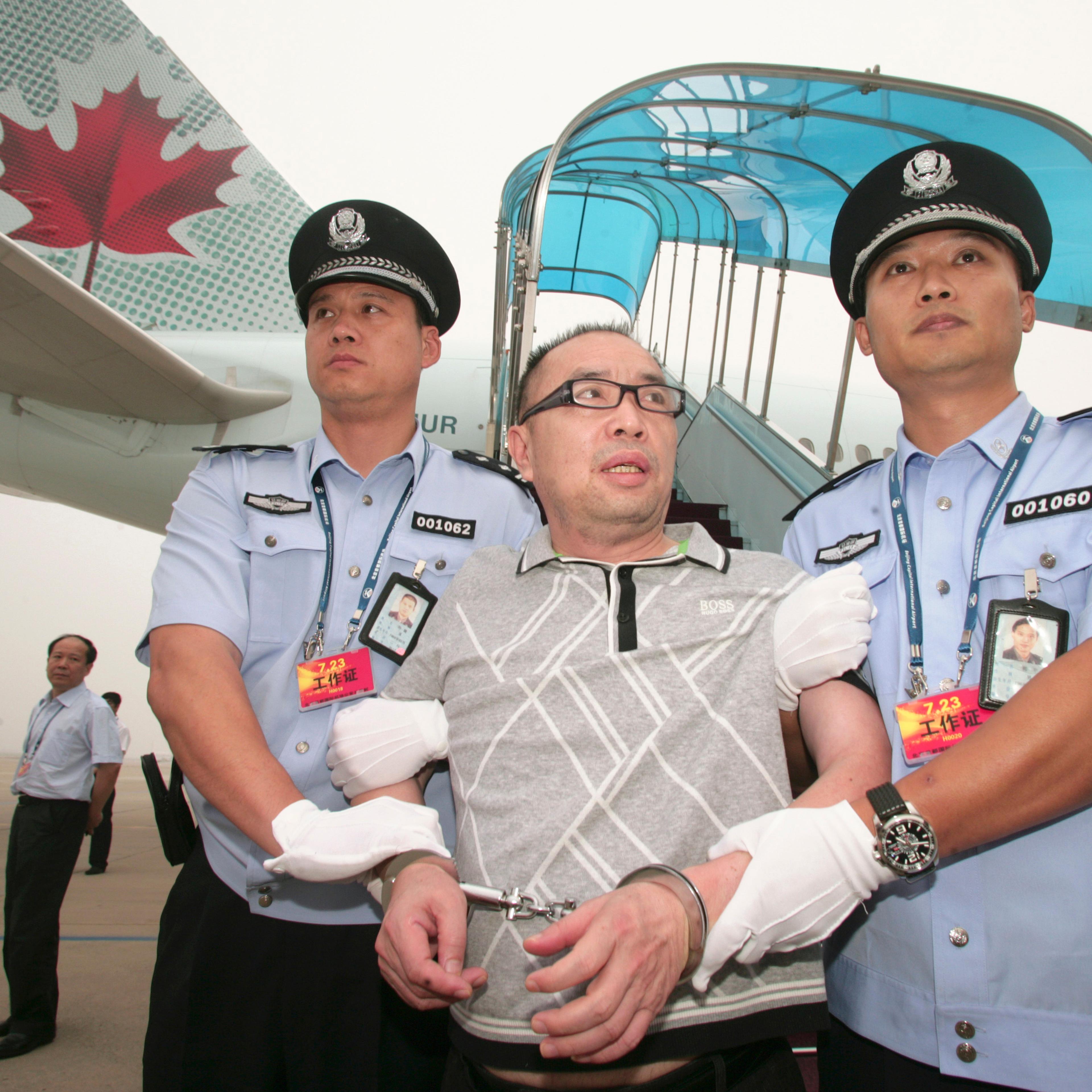 Then Chinese fugitive Lai Changxing is escorted back to Beijing from Canada, at Beijing International Airport