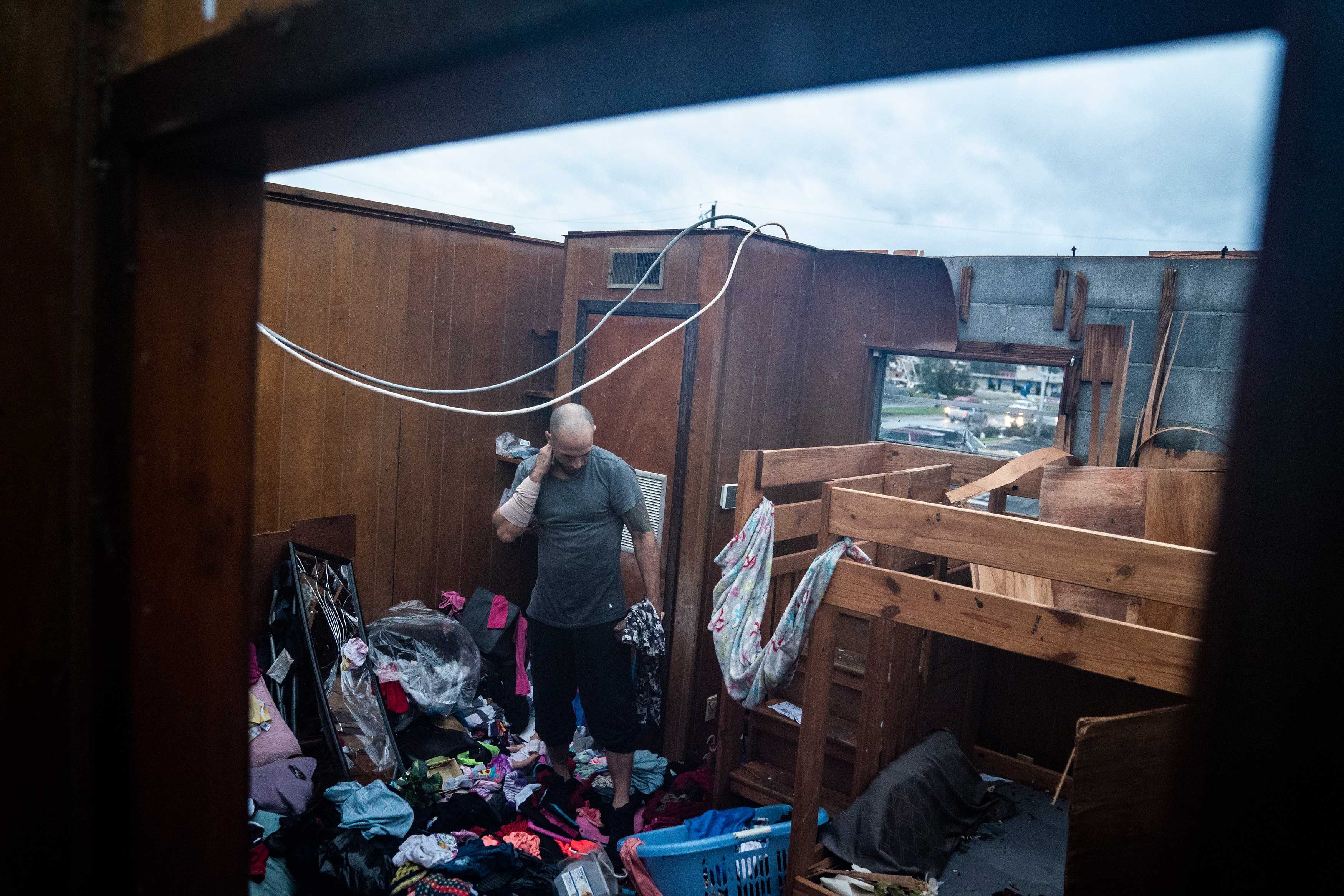 Jason Phipps looks through his families roofless apartment after category 4 Hurricane Michael made land fall along the Florida panhandle, on Oct. 10, 2018 in Panama City, Fla.