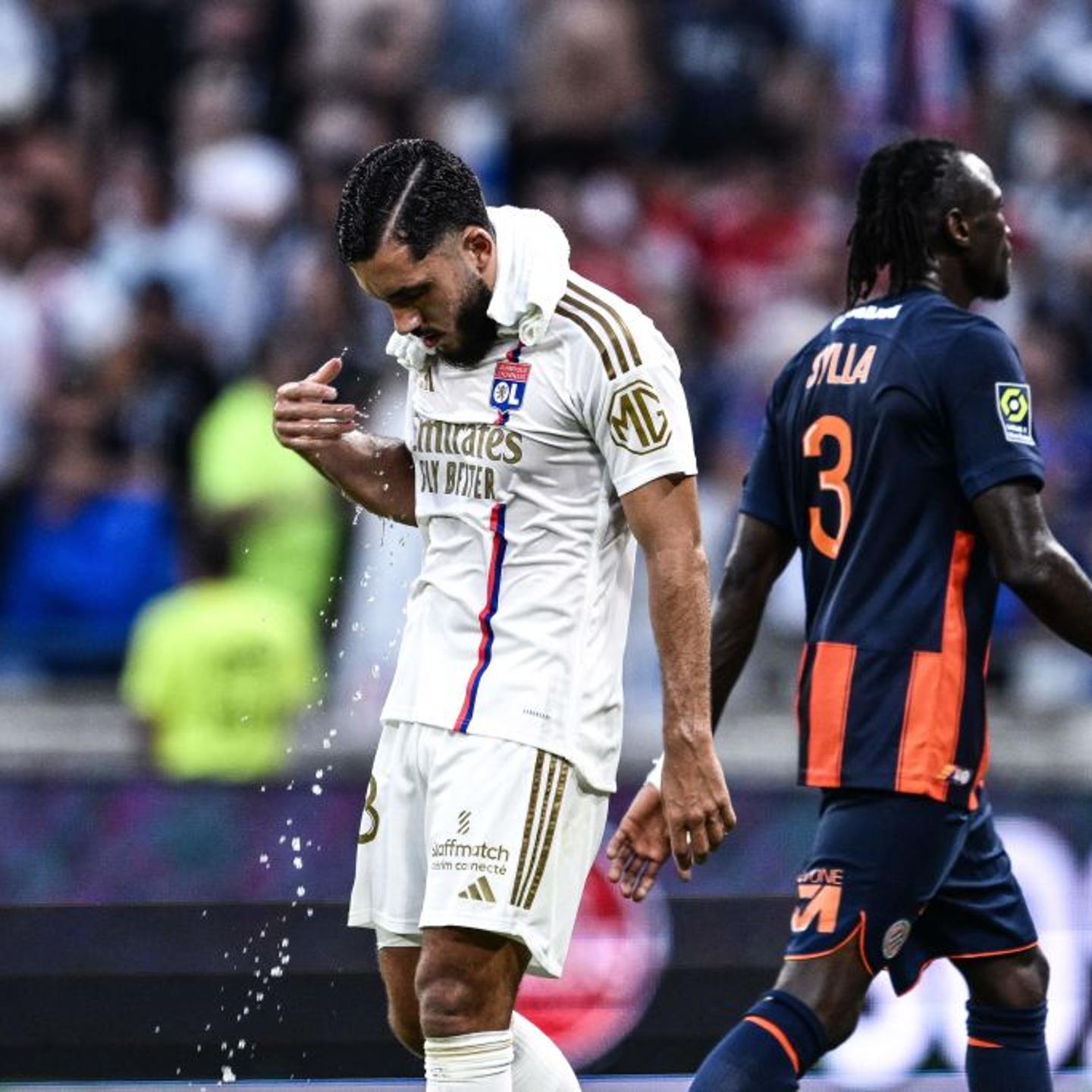 Lyon's French midfielder #18 Rayan Cherki wears a wet towel to get cooler during a break for hydratation due to a heatwave during the French L1 football match between Olympique Lyonnais (OL) and Montpellier Herault Sport Club (Montpellier Herault SC) at The Groupama Stadium in Decines-Charpieu, central-eastern France on August 19, 2023.