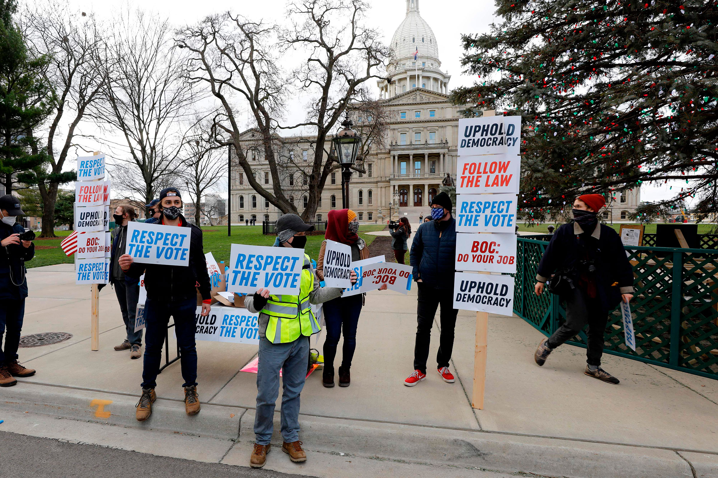 Supporters of President-Elect Joe Biden stand in front of the Michigan State Capital as the Michigan Board of State Canvassers vote today to certify the 2020 election in Lansing, Mich. on Nov. 23, 2020.