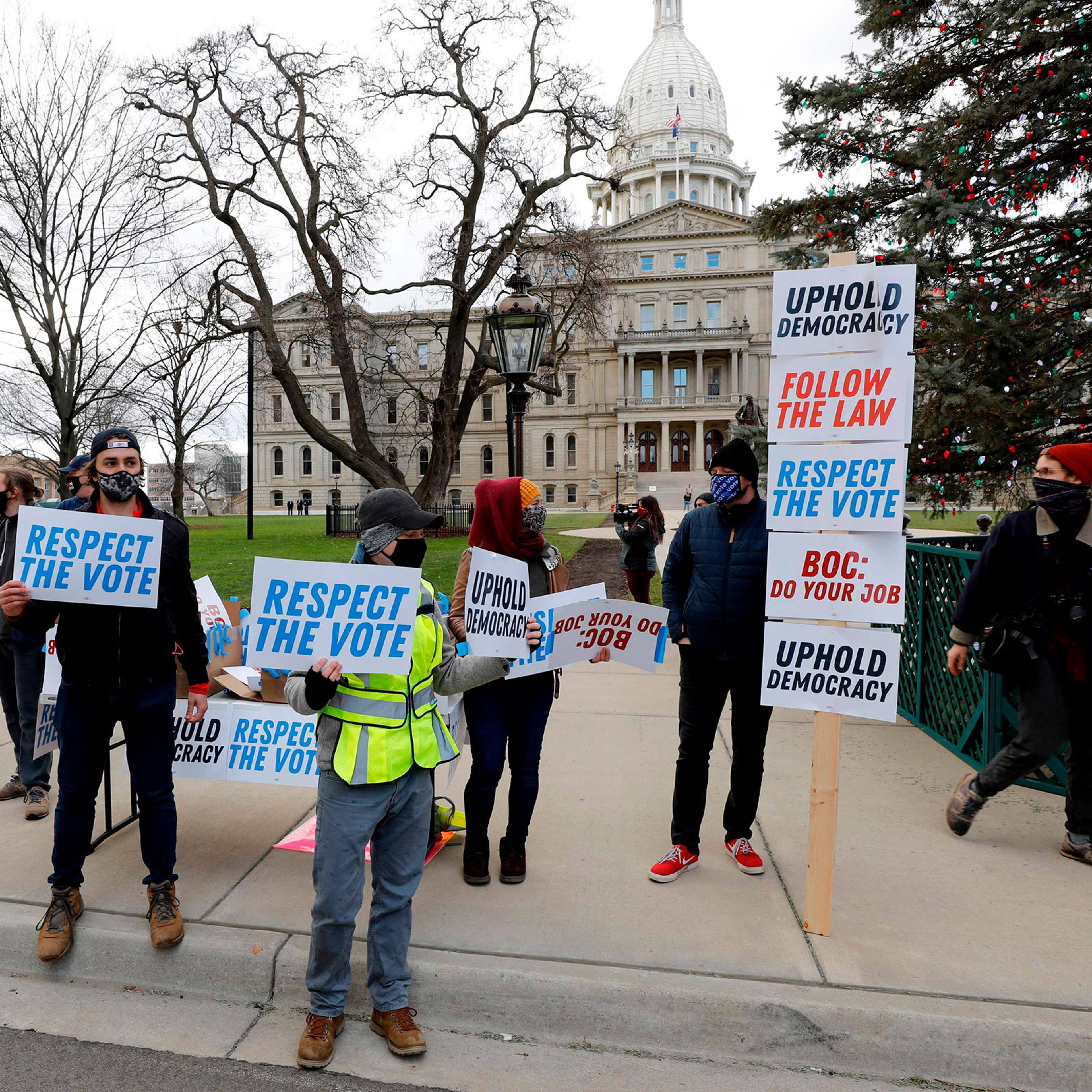 Supporters of President-Elect Joe Biden stand in front of the Michigan State Capital as the Michigan Board of State Canvassers vote today to certify the 2020 election in Lansing, Mich. on Nov. 23, 2020.