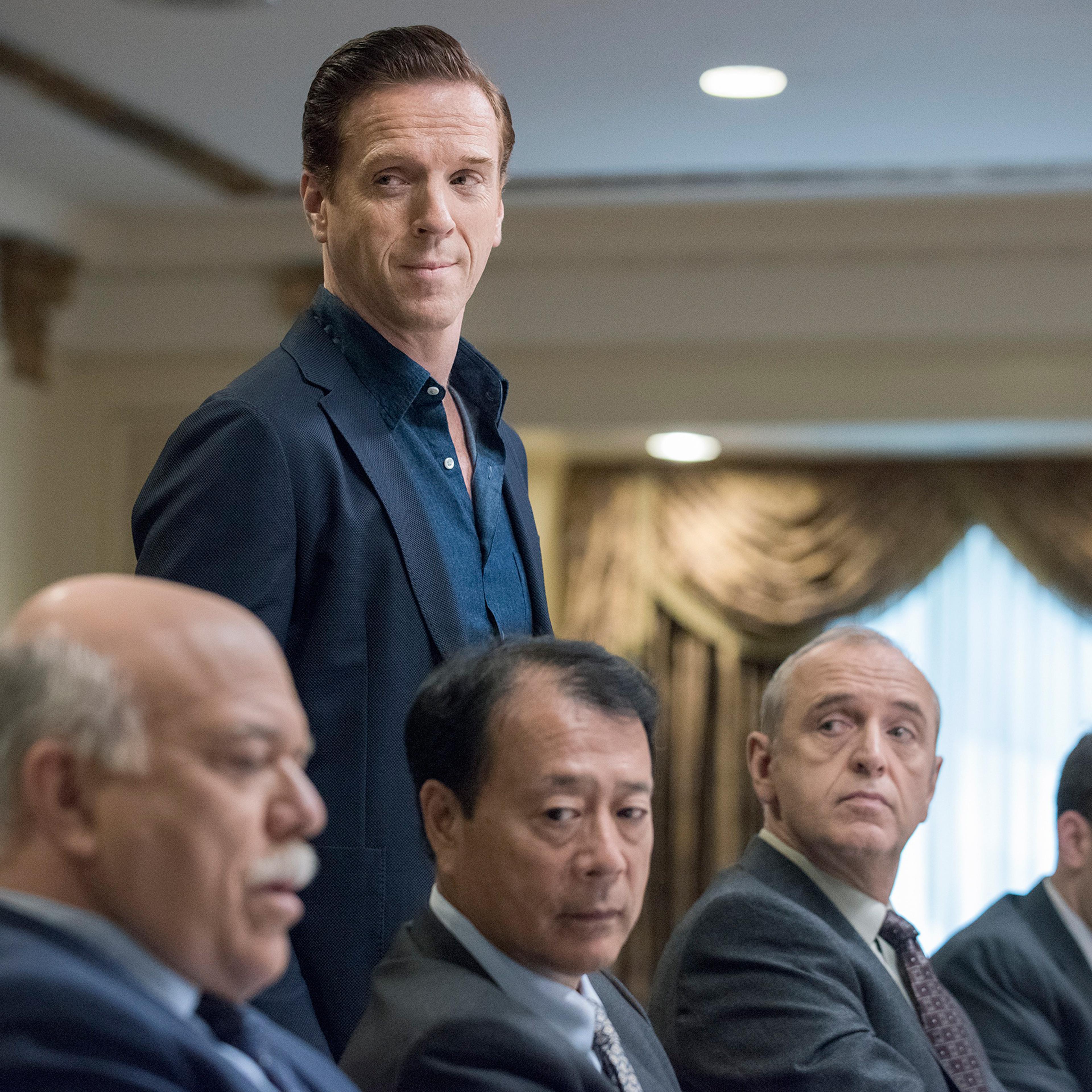 Damian Lewis, standing, plays the rapacious hedge funder Bobby “Axe” Axelrod in Billions