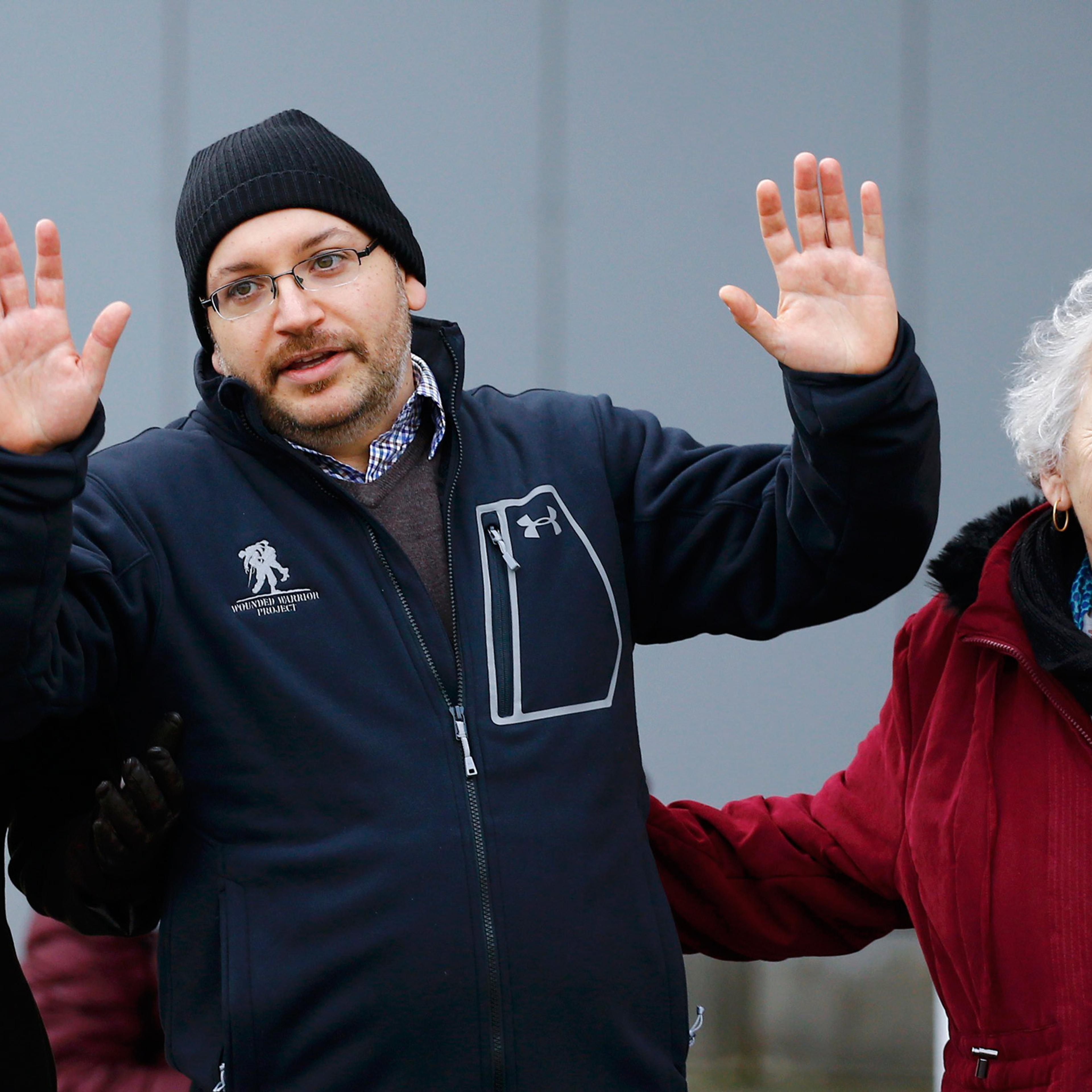 Jason Rezaian (C), one of the U.S. citizens recently released from detention in Iran, waves to media as he stands with his wife Yeganeh Salehi (L) and mother Mary Rezaian outside the Emergency Room of the Landstuhl Regional Medical Center (LRMC) in the s