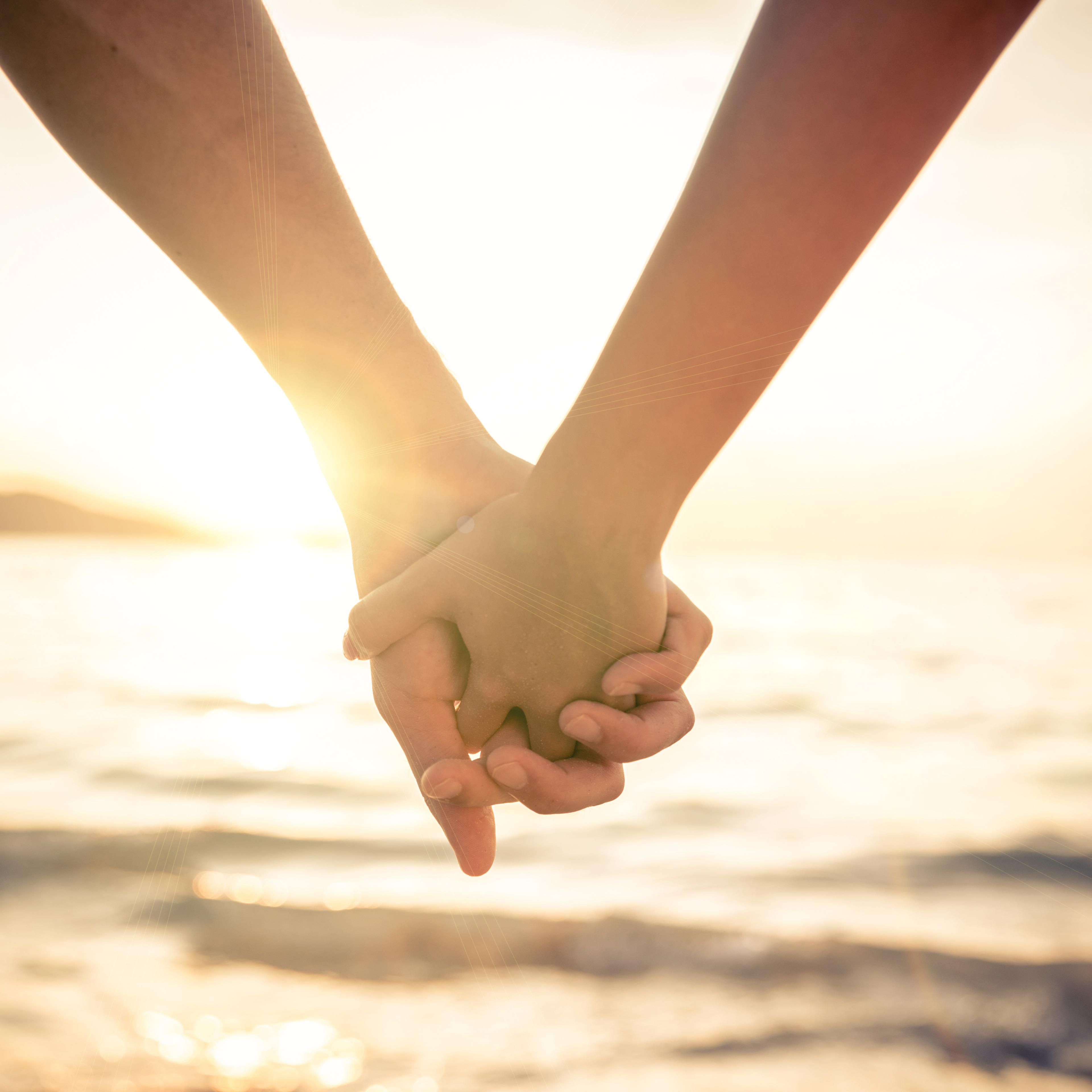 Couple holding hands at sunset