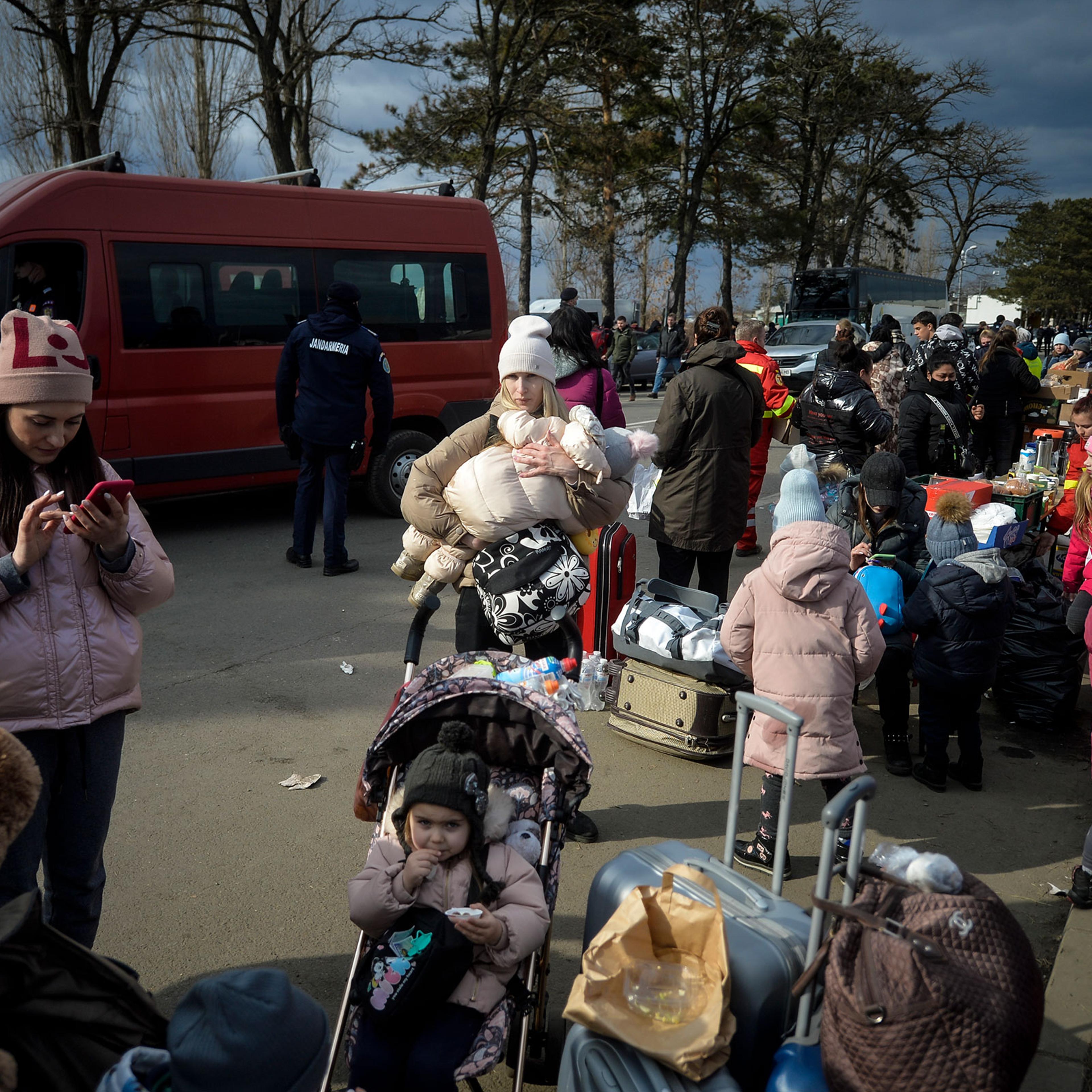 Refugees that fled the conflict from neighboring Ukraine, await for transportation at the Romanian-Ukrainian border, in Siret, Romania, on Feb. 27, 2022.