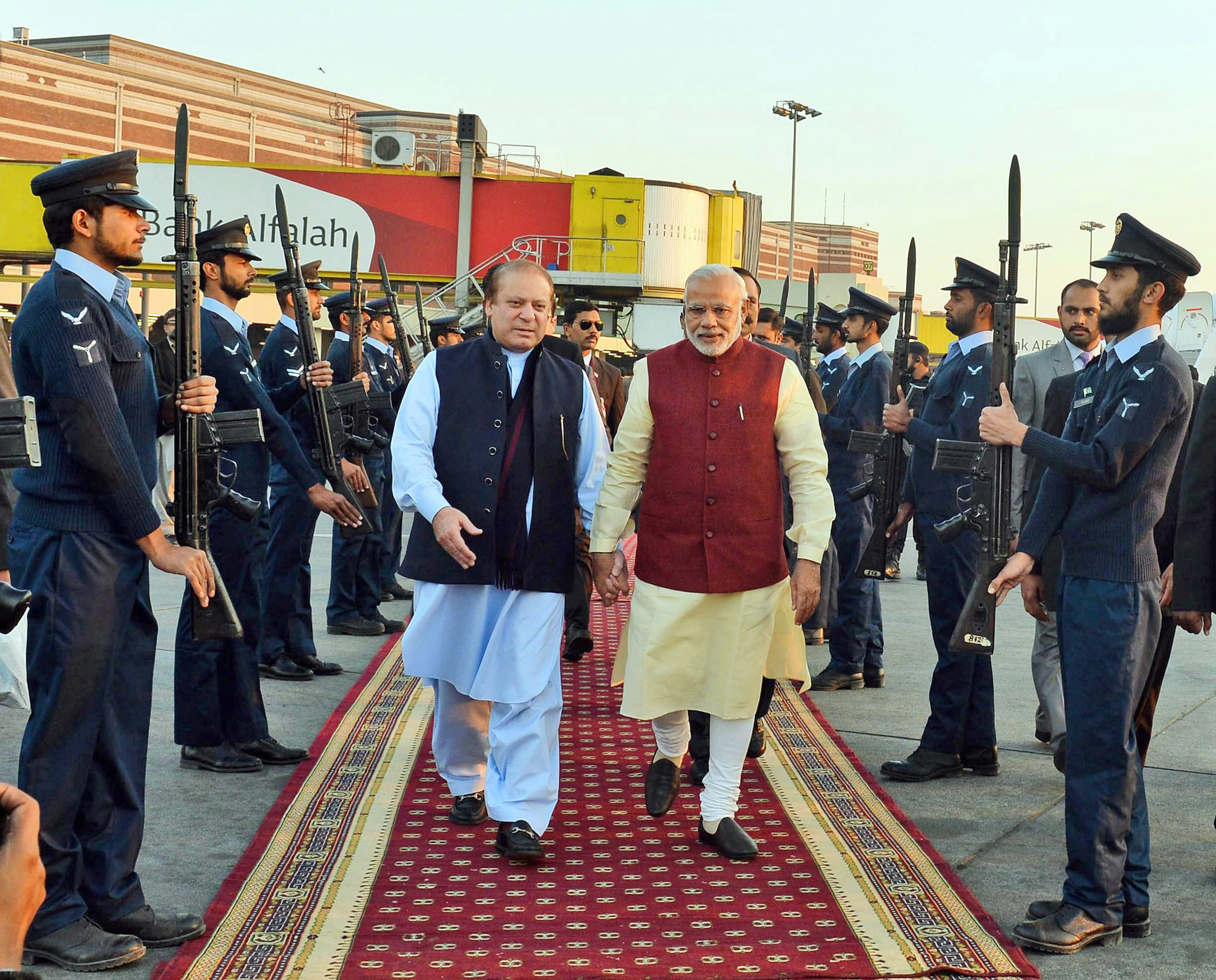 epa05080700 A handout photograph released by the Indian Press Information Bureau (PIB) on 25 December 2015 of Indian Prime Minister Narendra Modi (C-R) being welcomed by the Prime Minister of Pakistan, Nawaz Sharif (C-L), at the airport in Lahore, Pakist