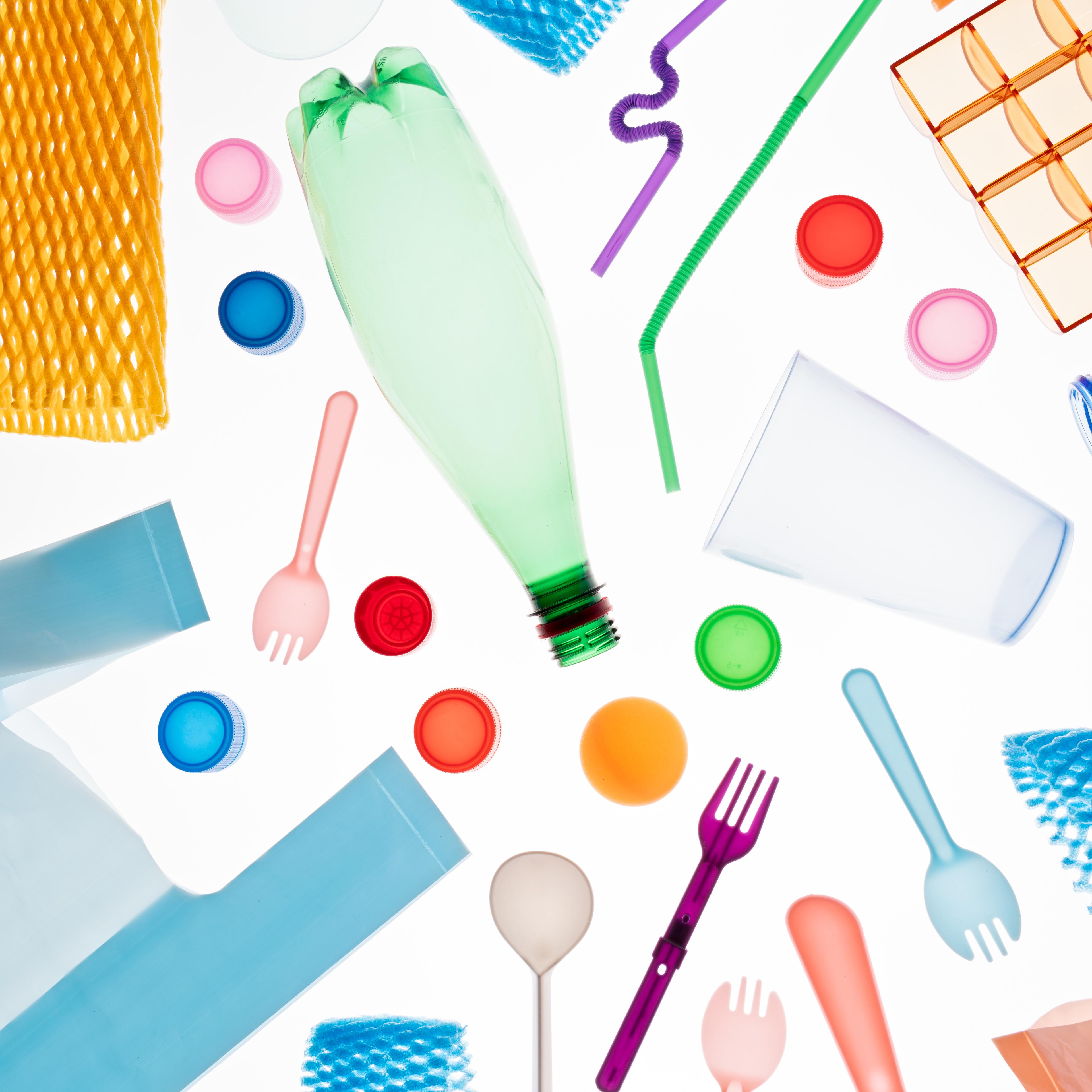 A Variety of Multi Colored Plastic Garbage Flat Lay on White