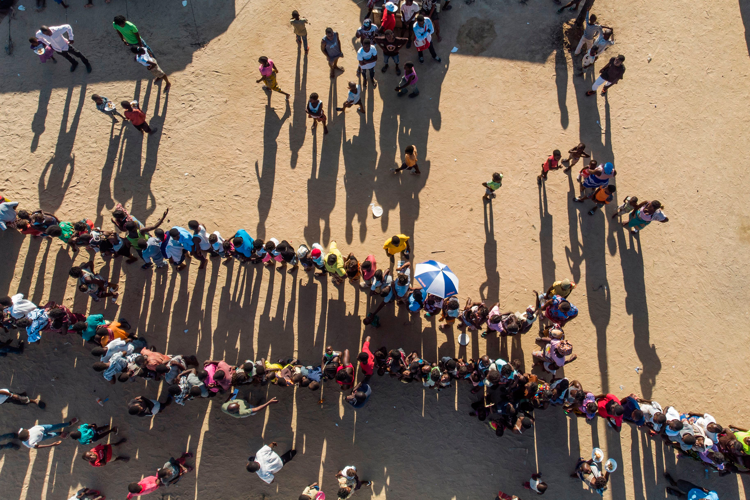 Internally displaced persons wait for supplies at the Picoco refugee camp in Beira, on April 1, 2019.