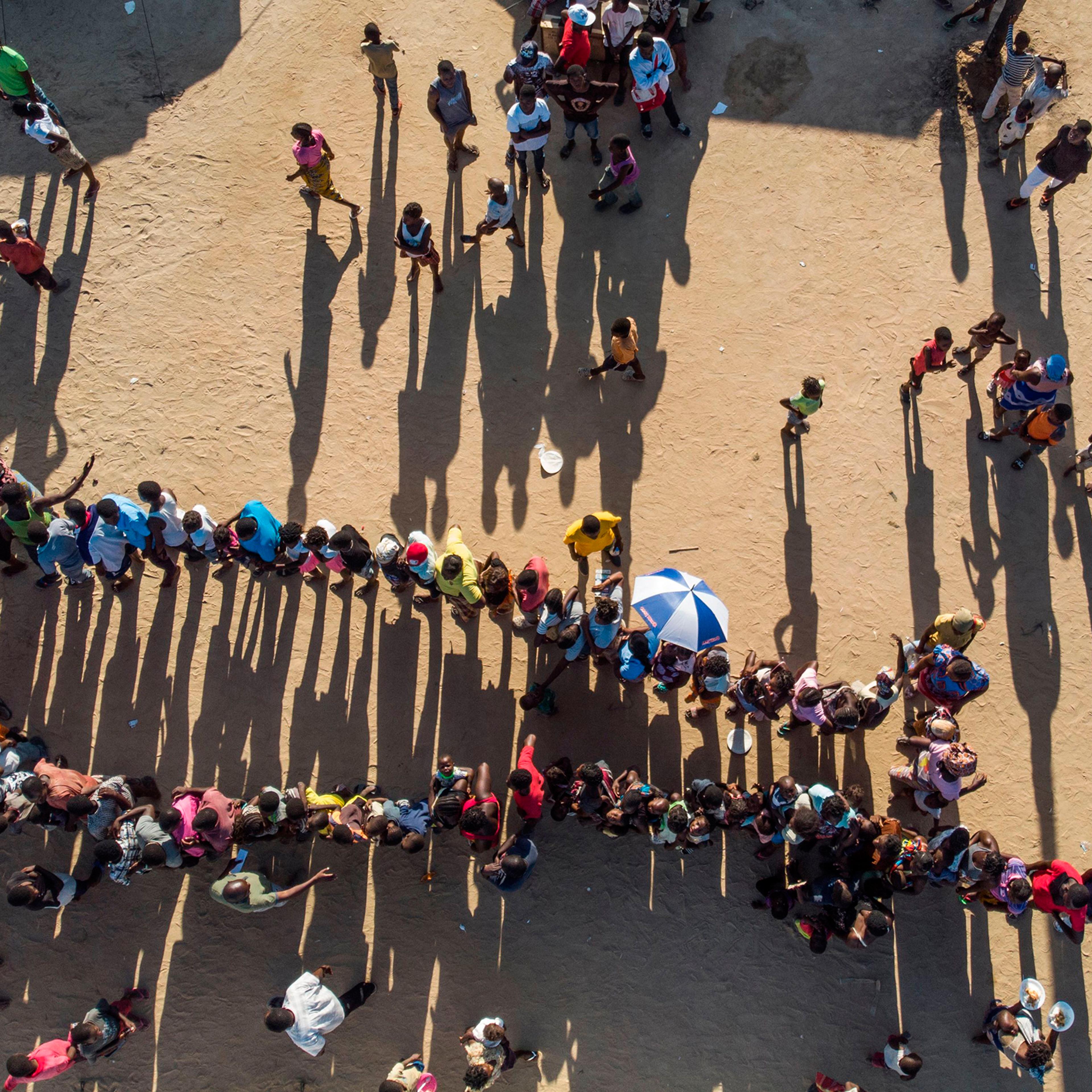 Internally displaced persons wait for supplies at the Picoco refugee camp in Beira, on April 1, 2019.
