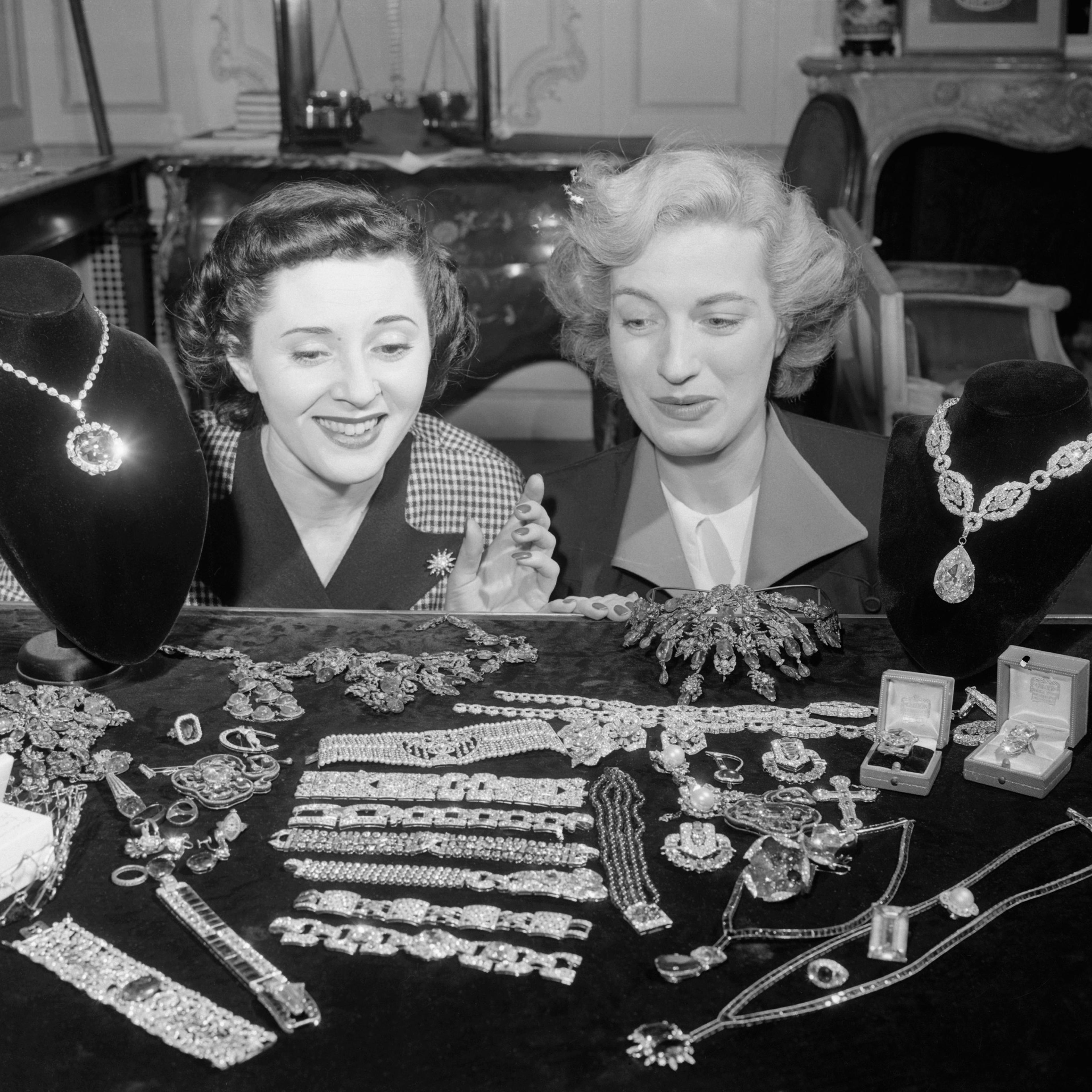 Jill Ciraldo and Grace Flynt are admiring the McLean Jewel Collection at the establishment of Harry Winston, Inc., international jewer dealer, of New York. The Hope Diamond is at left above and the "Star of the East" at right, 1949.