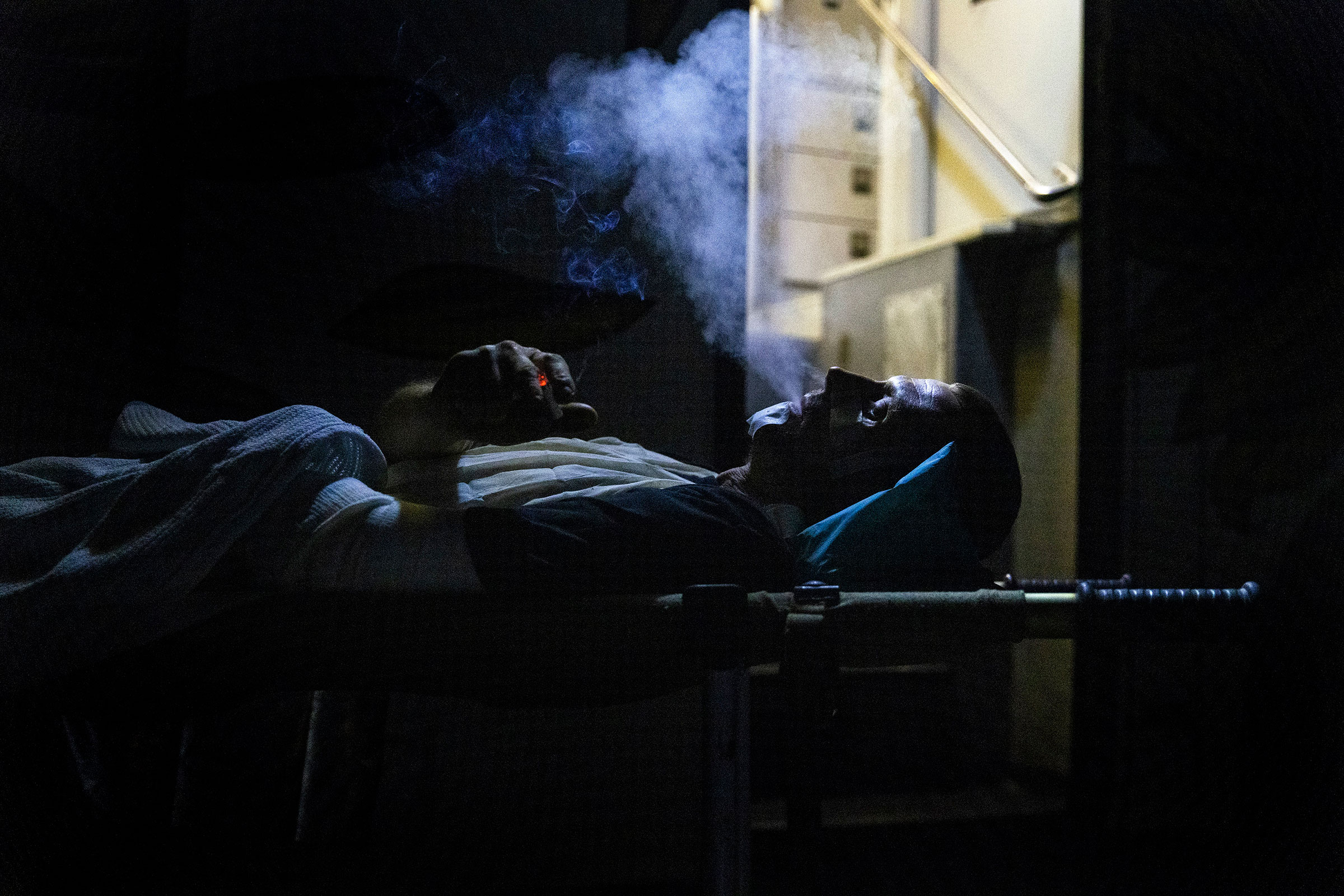 A wounded Ukrainian soldier on a medical stretcher smokes a last cigarette before being loaded onto a mobile hospital bus by medics from the Hospitallers, a Ukrainian volunteer medical battalion providing first aid and evacuation assistance for wounded U