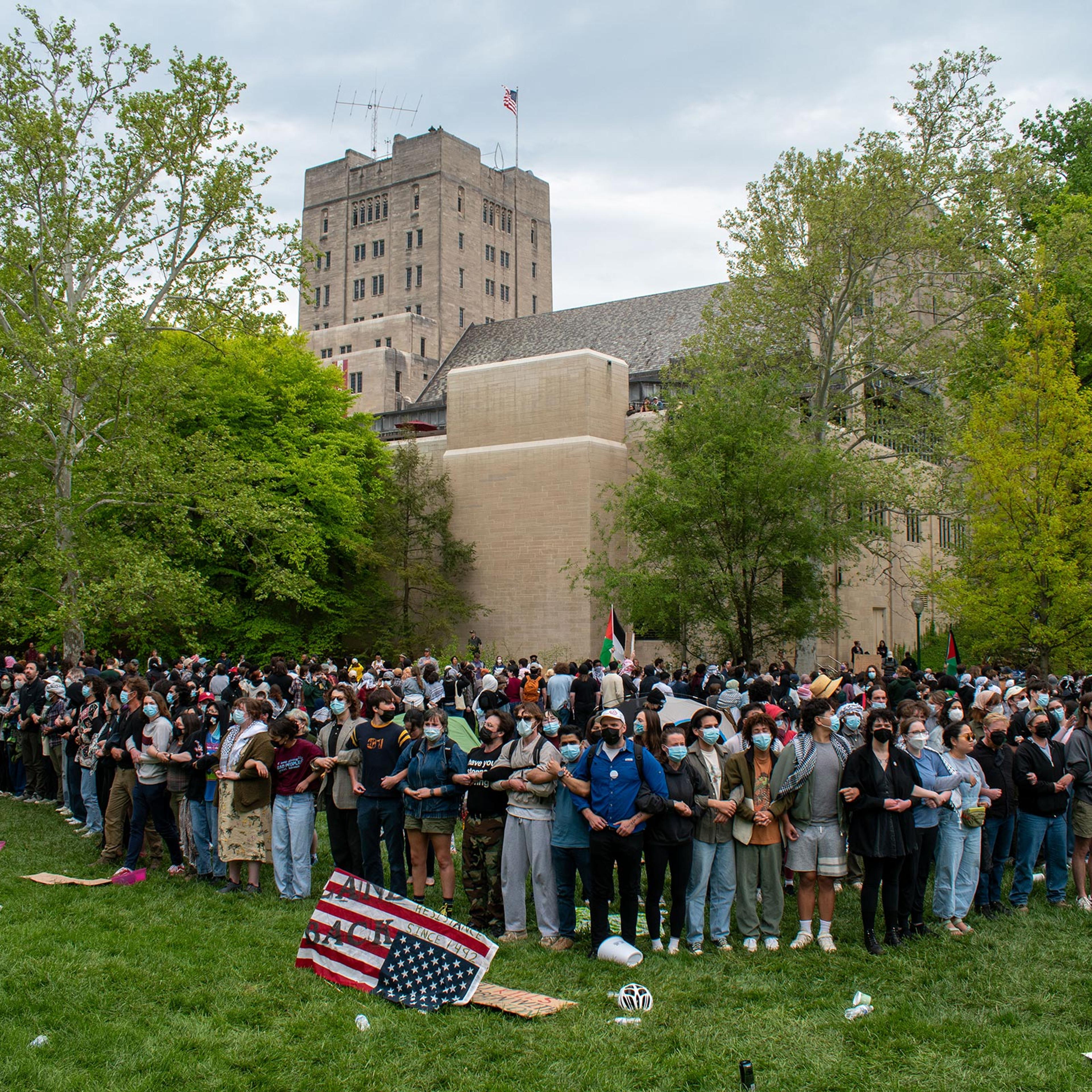 More than 100 pro-Palestinian protesters link arms to surround an encampment on April 26, outside the Indiana Memorial Union in Bloomington. Inside the encampment, there was food, medical supplies, tents, and a pile of backpacks.