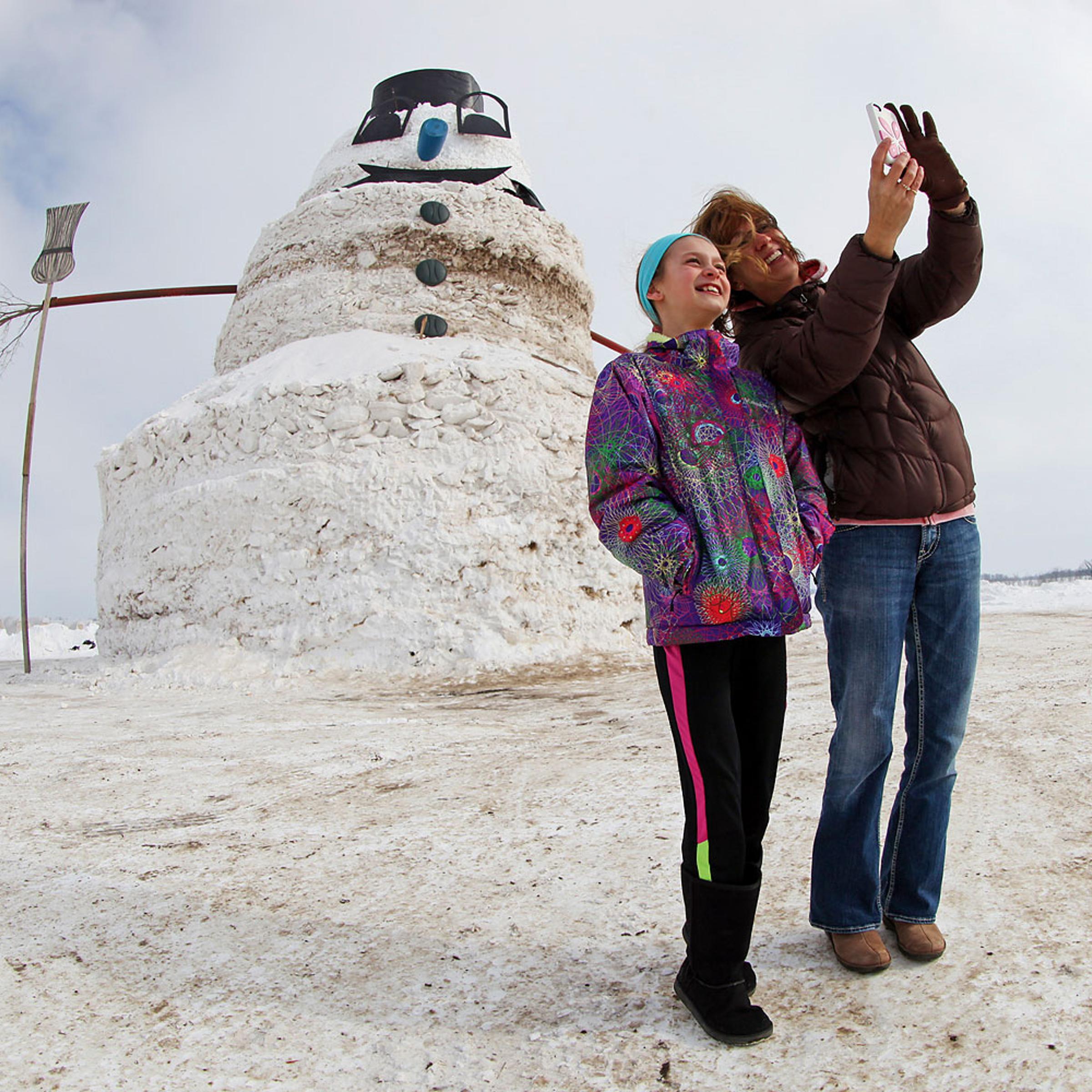 Mother and daughter photograph themselves in front of 50 foot snowman in Minnesota