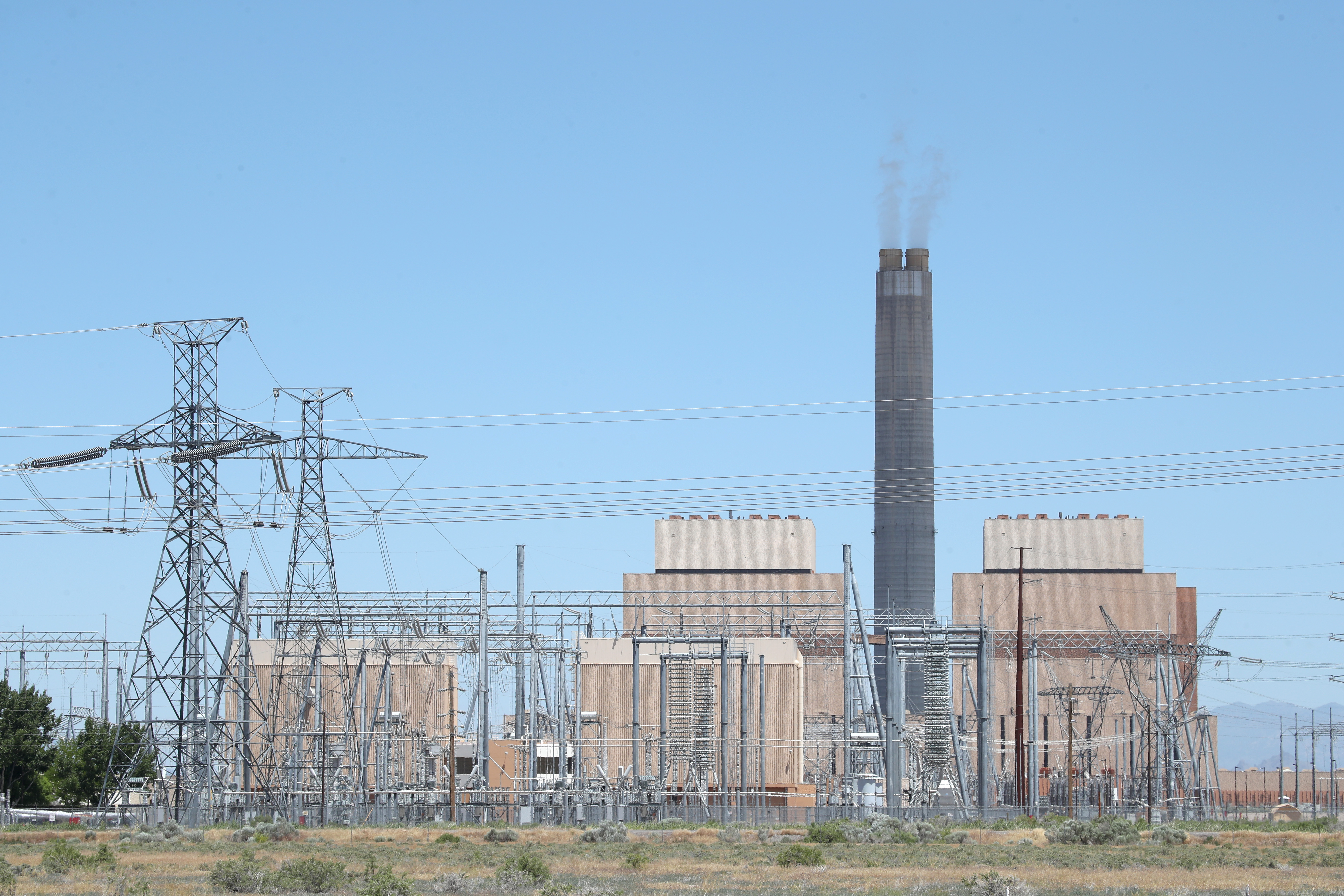 Power lines and a power station stand beside the Intermountain Power Agency coal fired power plant outside Delta, Utah. This plant, like others across the country, is shifting from coal to renewables, which is driving down the energy sector's emissions.