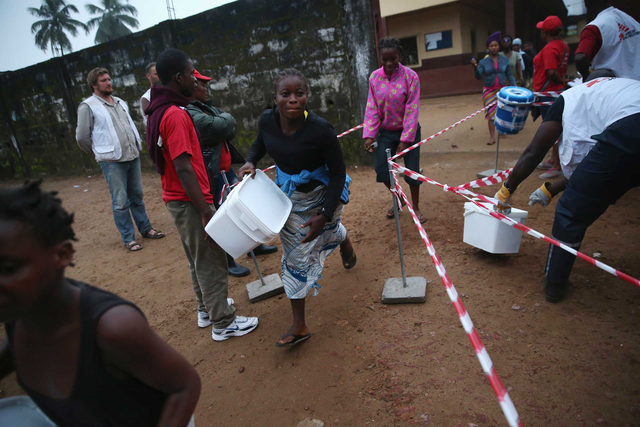 Residents take home family and home disinfection kits distributed by Doctors Without Borders, on Oct. 4, 2014 in New Kru Town, Liberia.